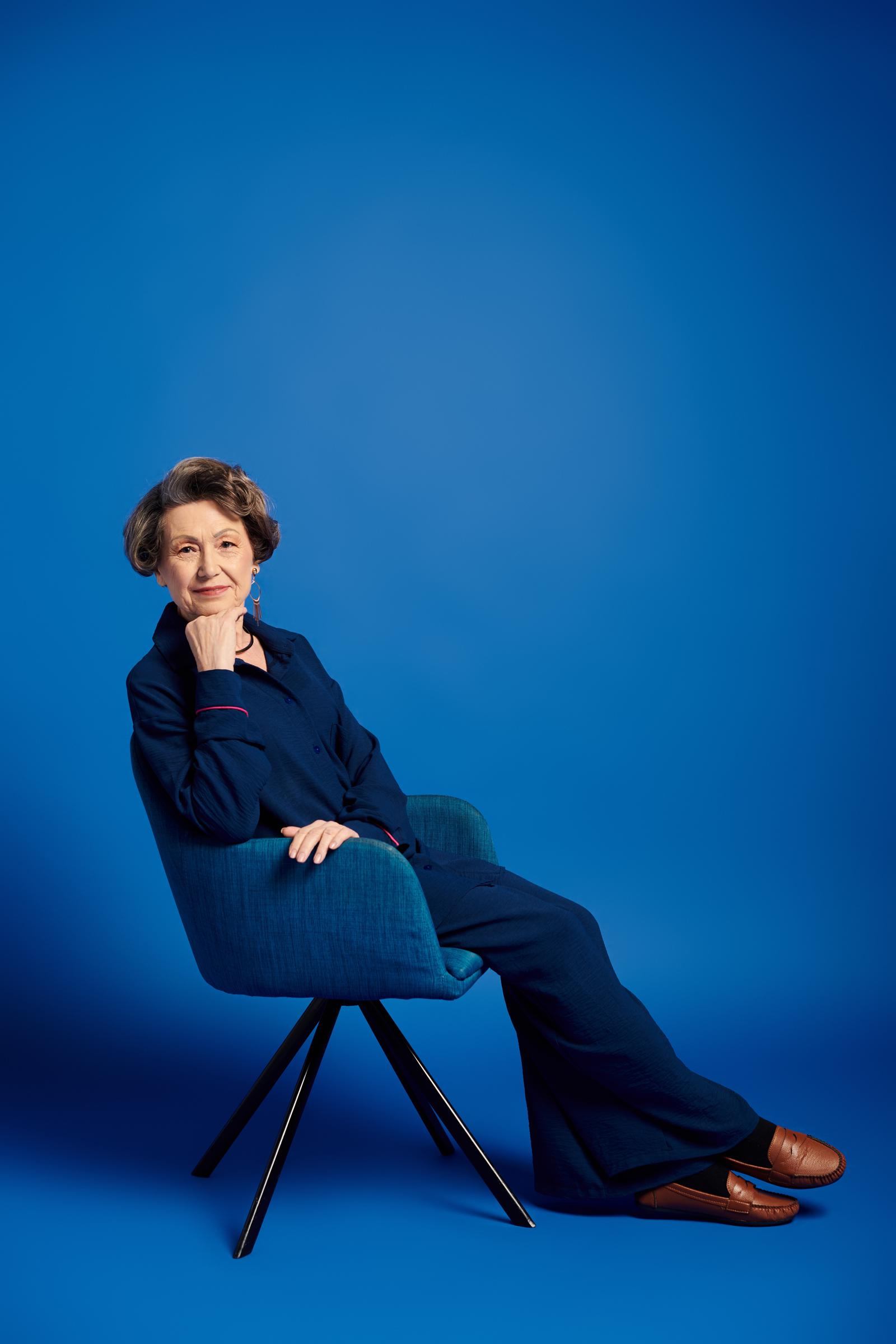 A confident and smartly dressed woman sitting on a chair | Source: Shutterstock