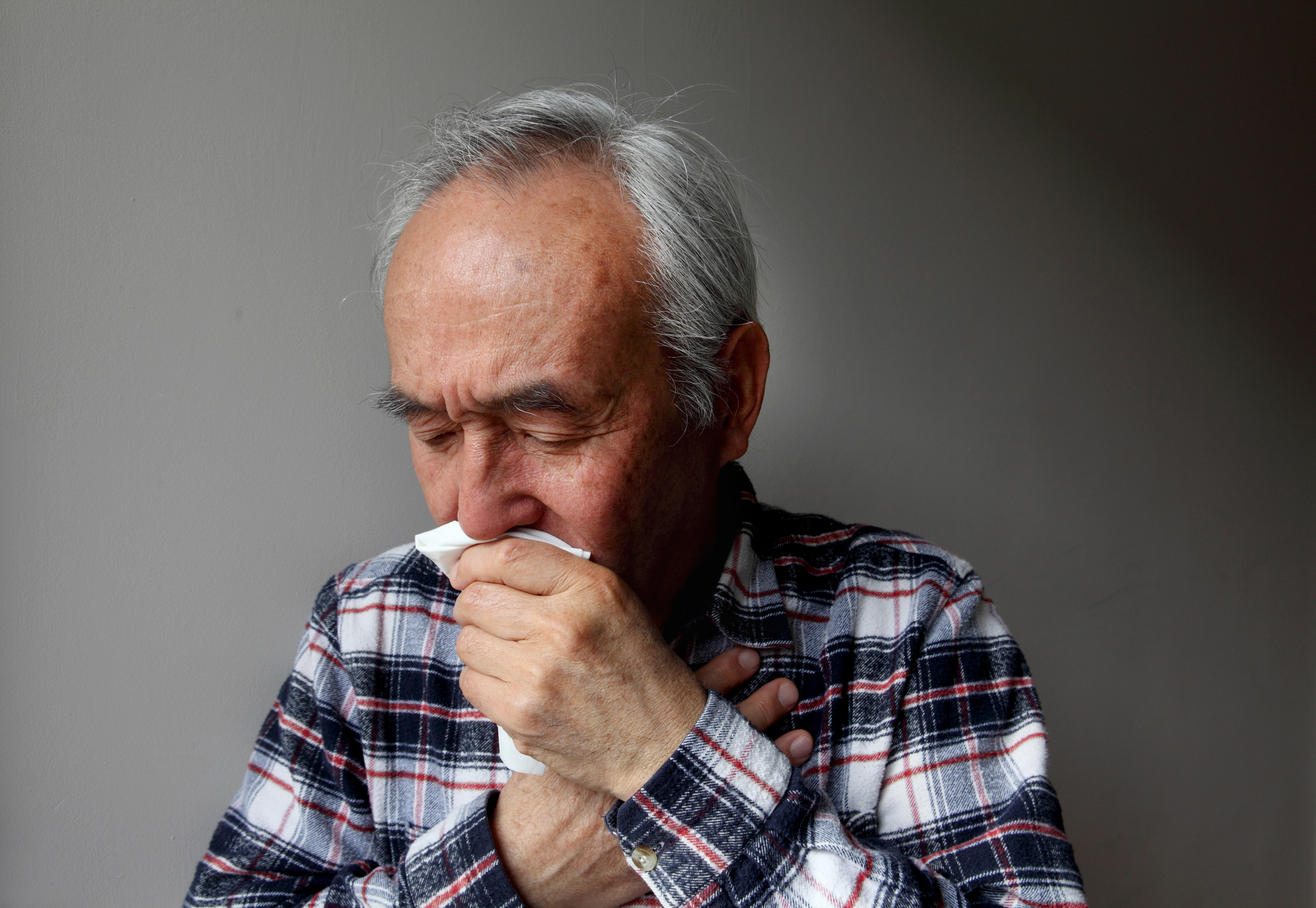 Old man coughing into a napkin | Source: Getty Images