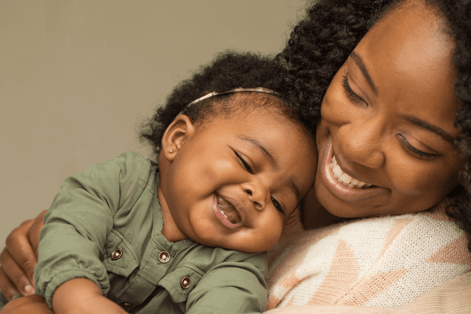 Eine Frau und ein Baby kuscheln lächelnd. | Quelle: Shutterstock