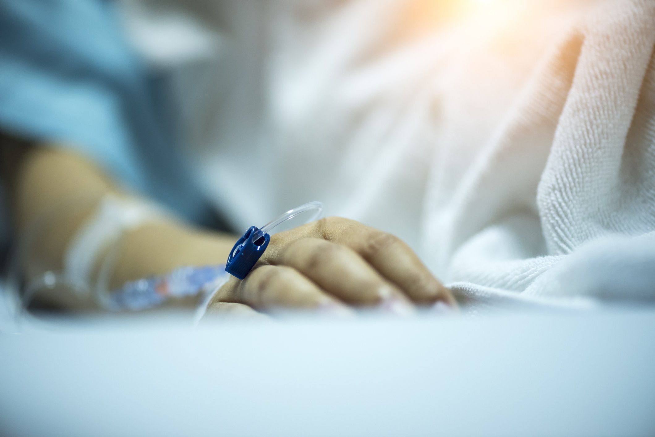 Hand eines Patienten auf Krankenhausbett | Quelle: Getty Images