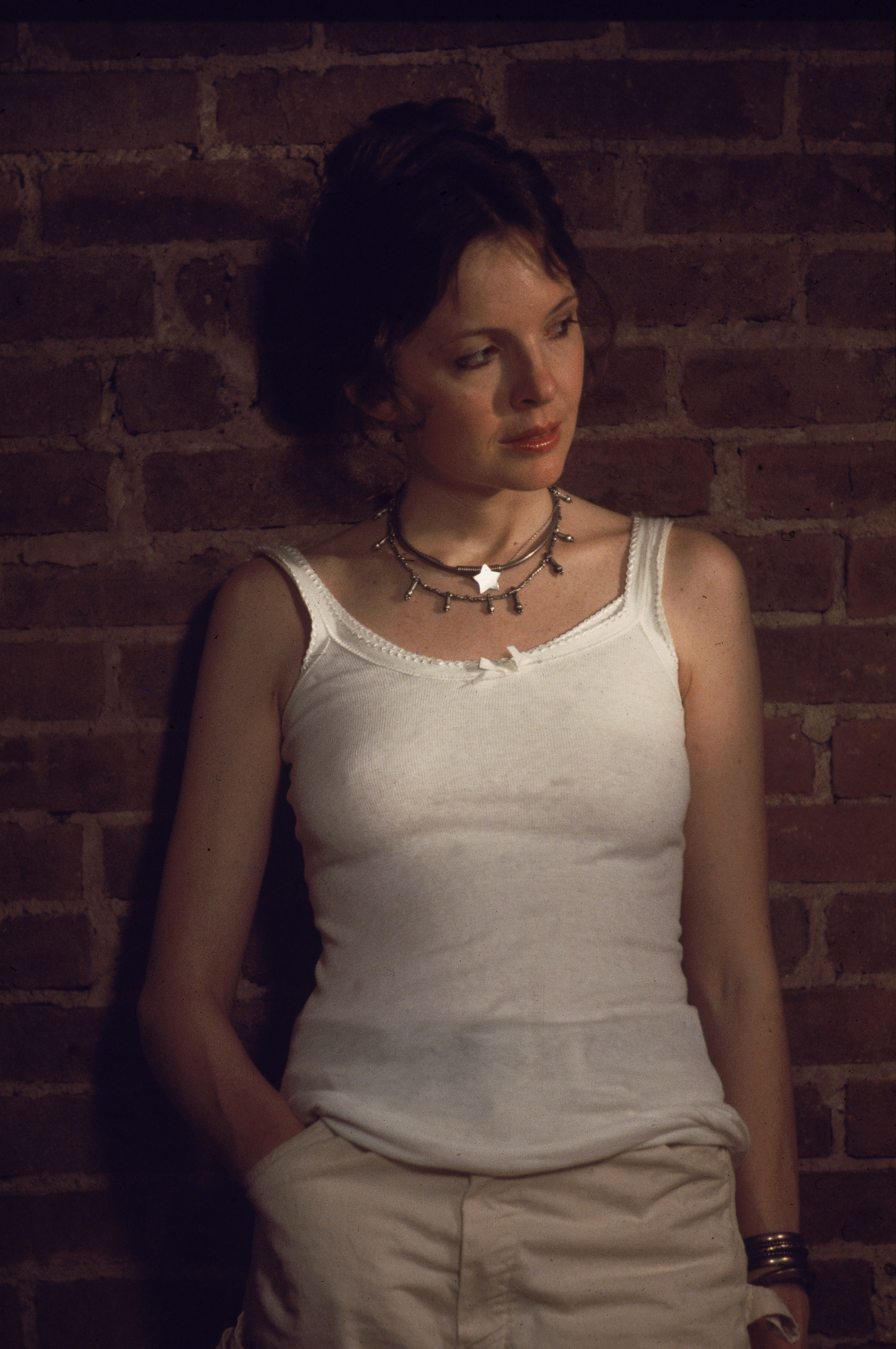 Diane Keaton wears a white tank top and leans against a brick wall in a scene from "Annie Hall," directed by Woody Allen, in New York, circa 1977. | Source: Getty Images