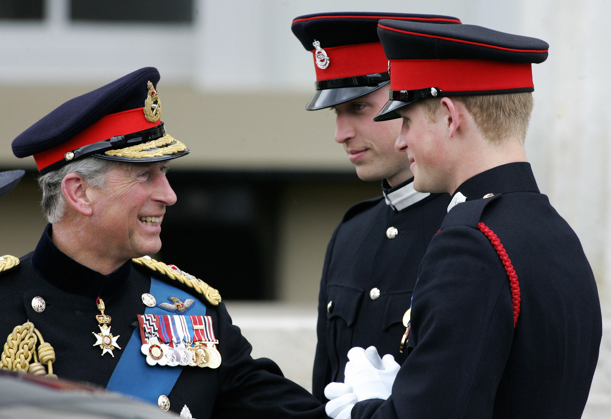 Britain's Prince Charles (L) speaks with his two sons Prince's William (C) and Harry (R) after attending the Sovereign's Parade at the Royal Military Academy in Sandhurst, southern England, April 12, 2006. | Source: Getty Images