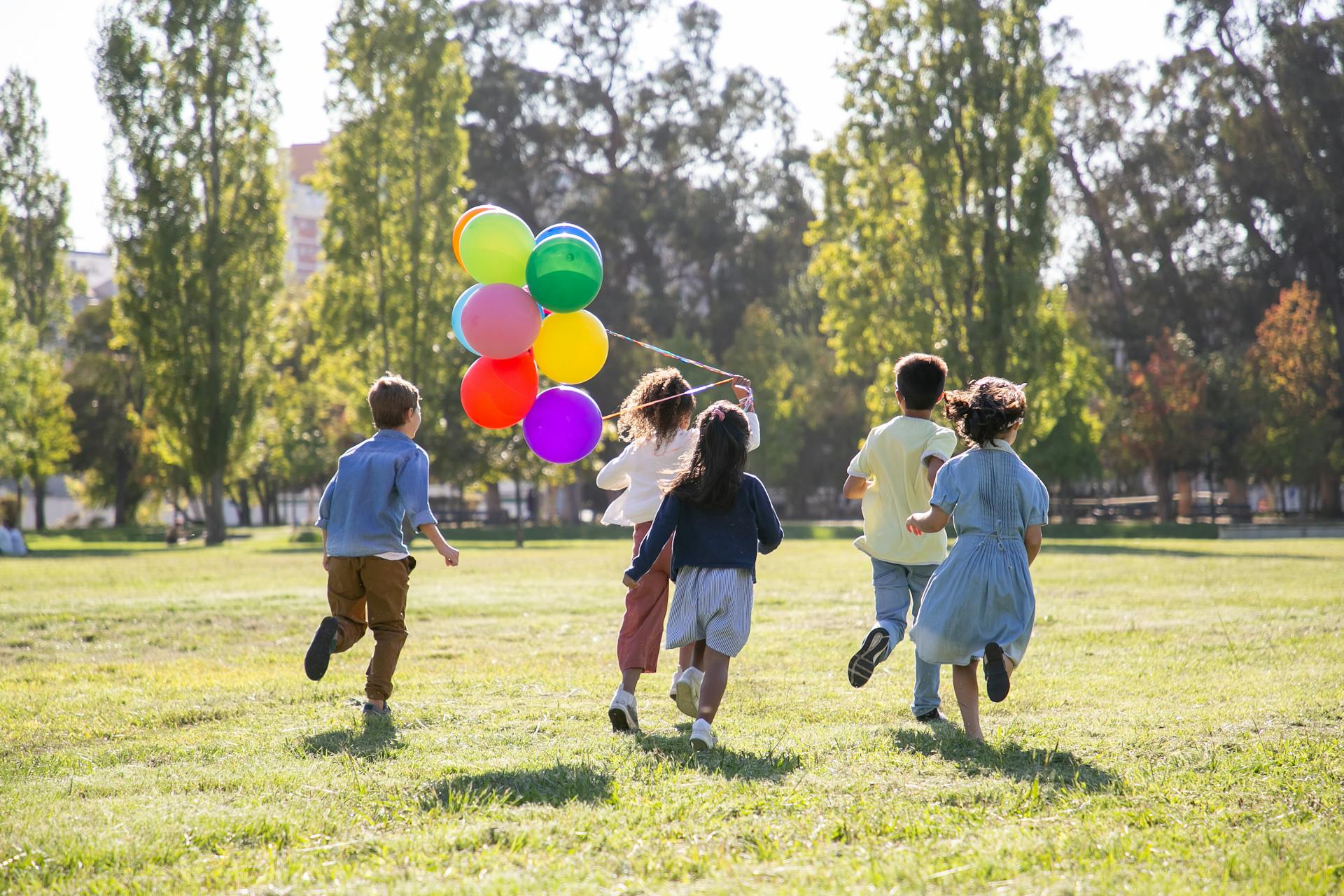 Children playing with balloons in a park | Source: Pexels