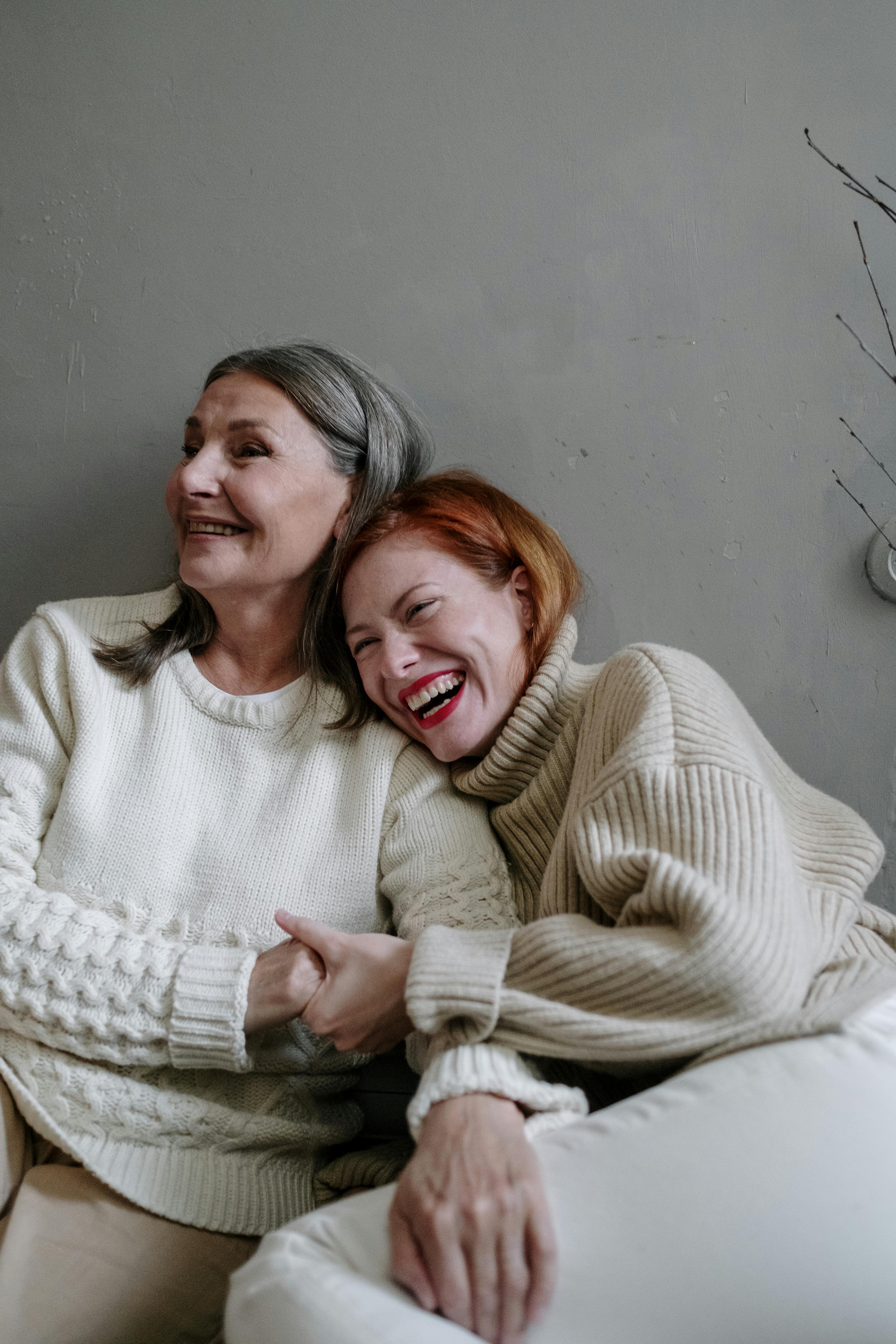 A happy mother and daughter laughing and holding hands | Source: Pexels