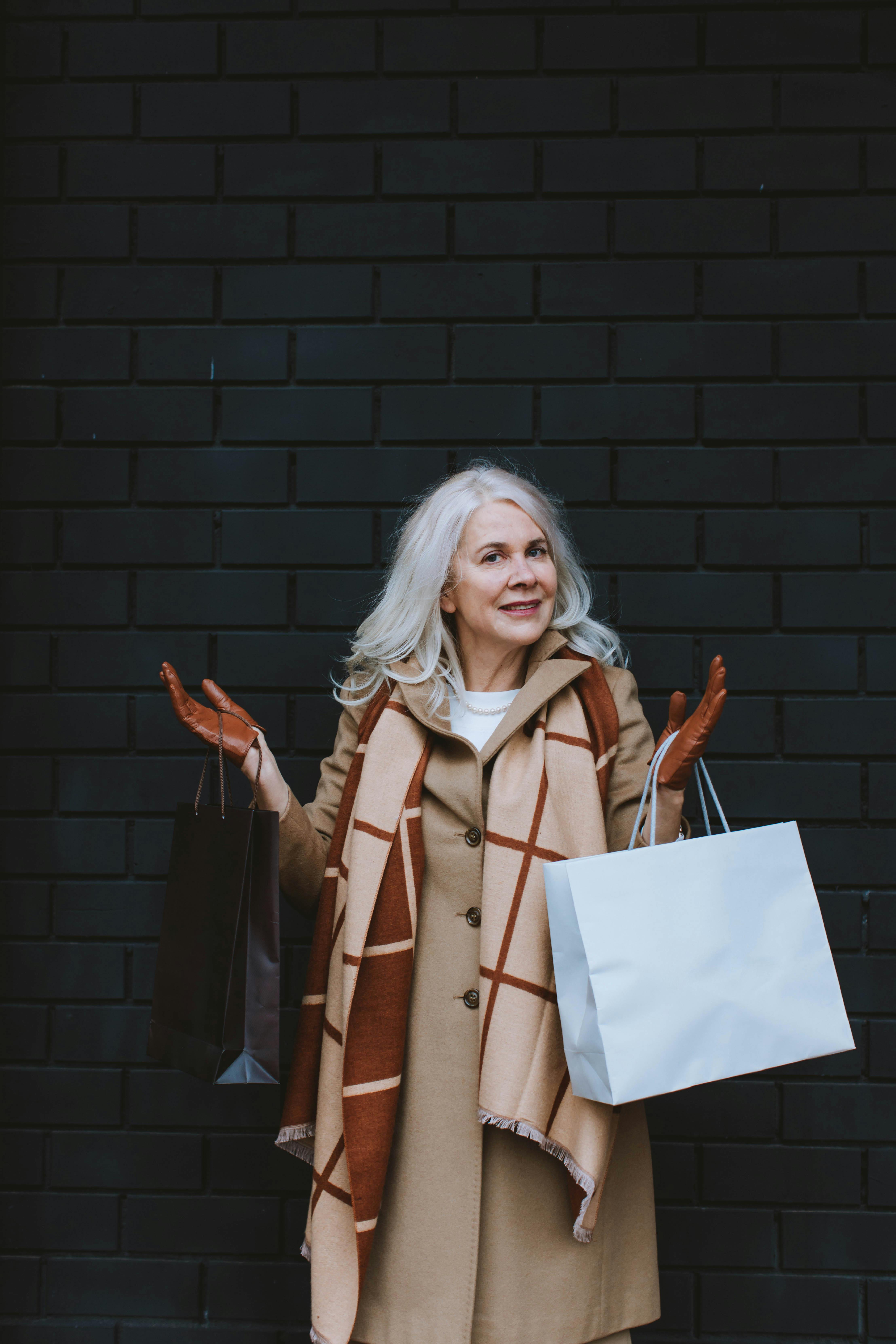 An elegant older woman holding shopping bags | Source: Pexels