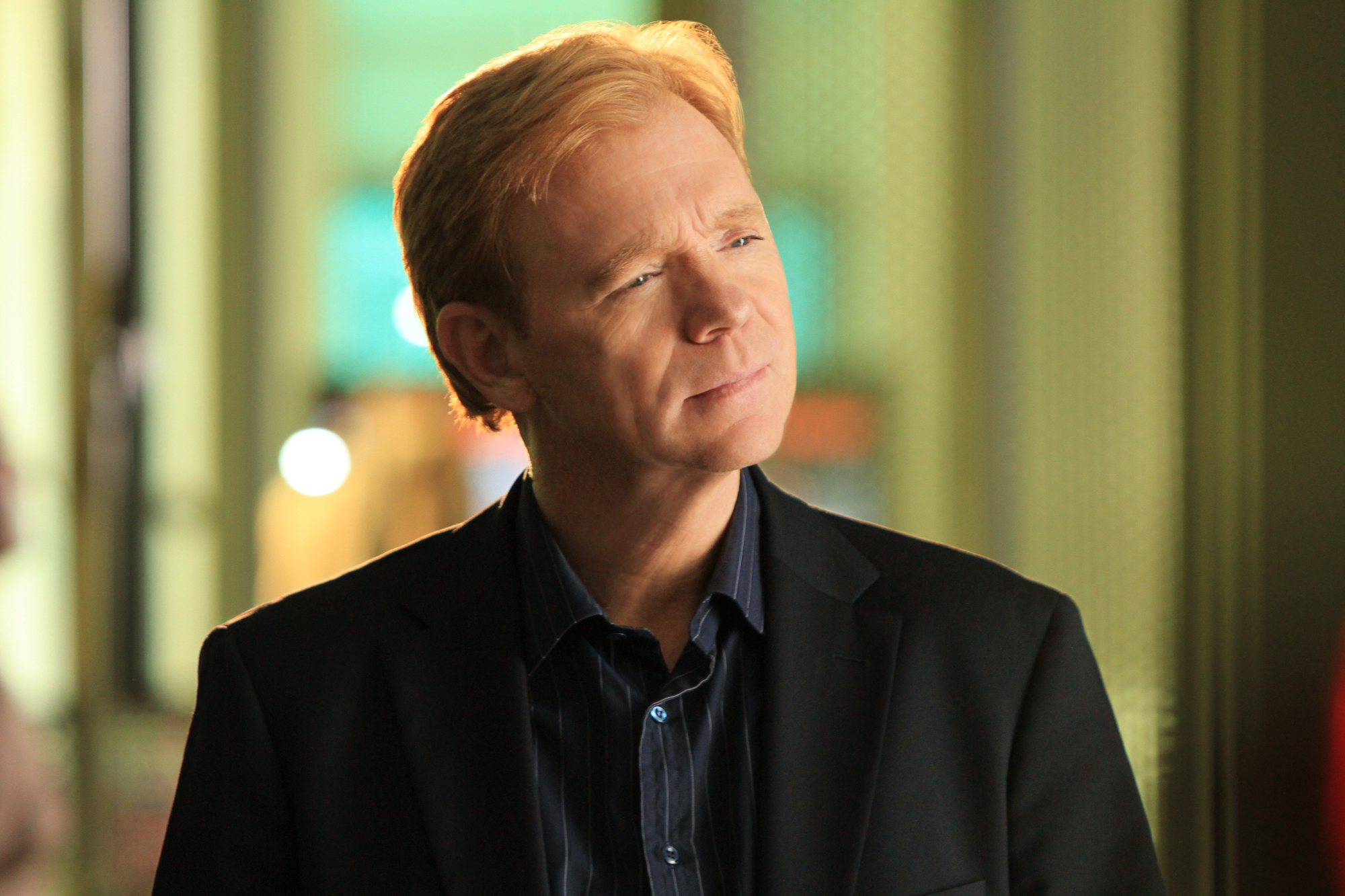 David Caruso appears in a dramatic "CSI: Miami" scene from "By the Book," wearing a dark suit as Horatio Caine while investigating a mysterious death inside a deserted mansion.