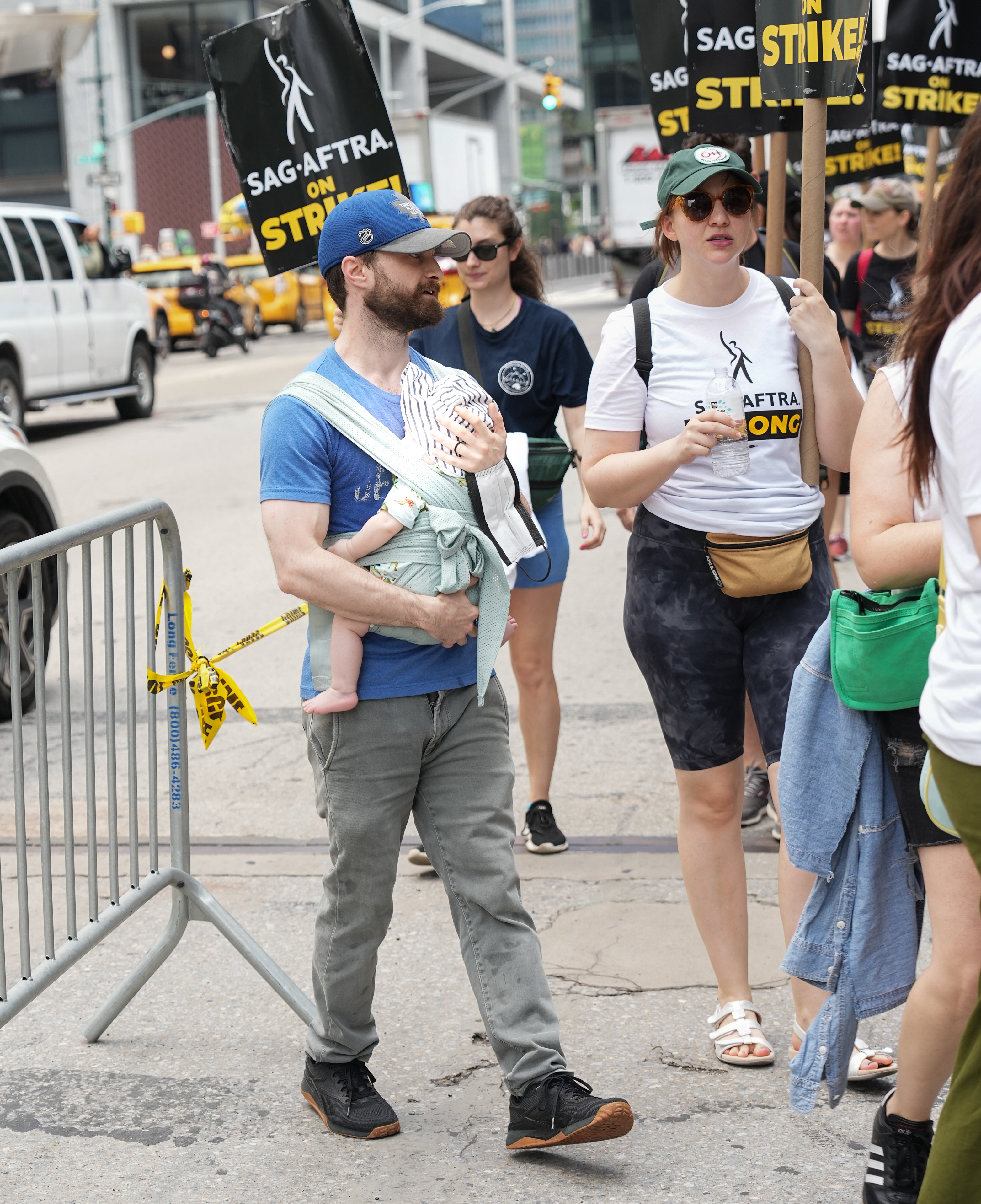 Daniel Radcliffe, his son, and Erin Darke join the picket line in New York City on July 21, 2023 | Source: Getty Images