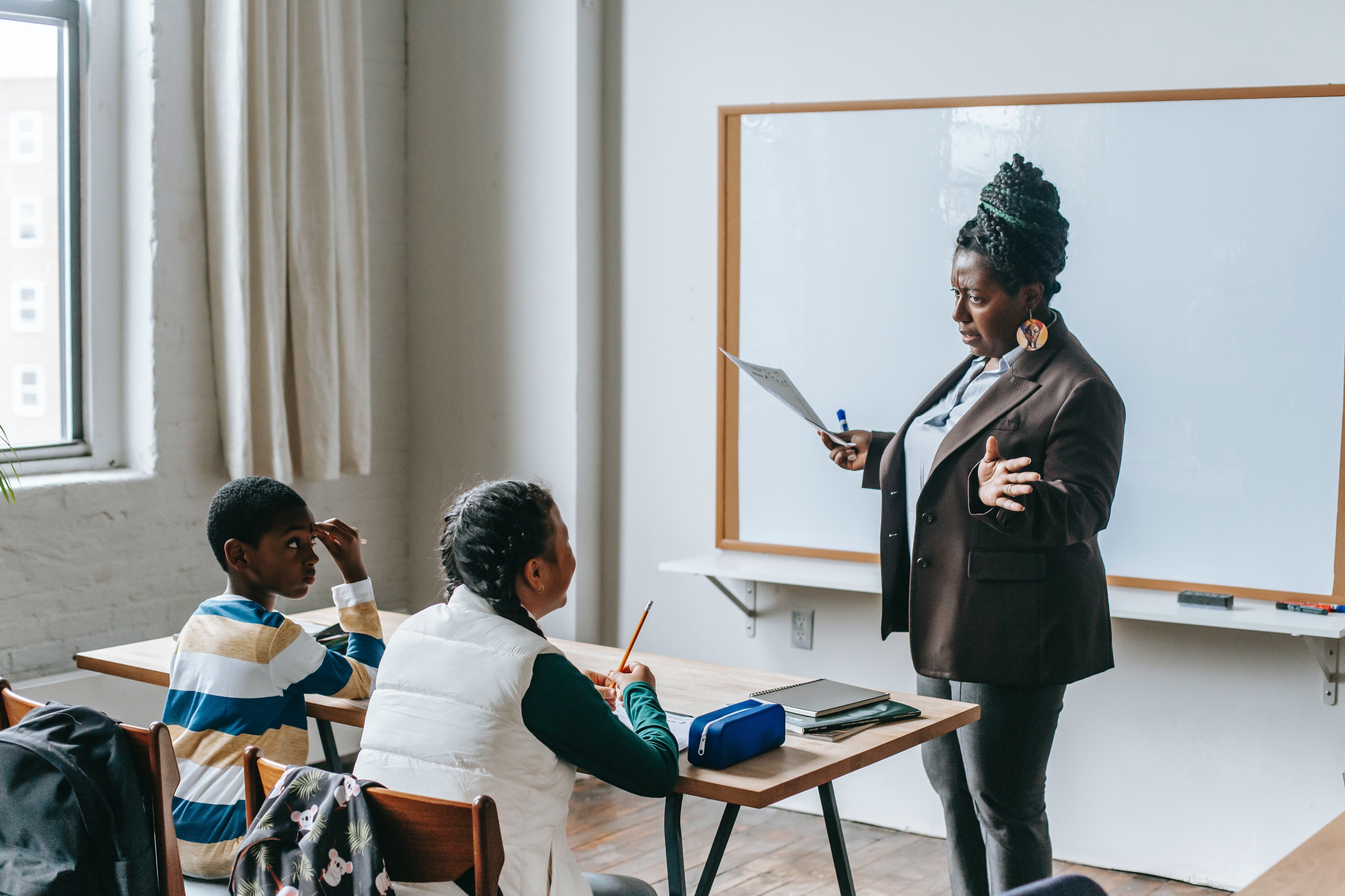 A teacher talking to students in class. | Photo: Pexels/Katerina Holmes