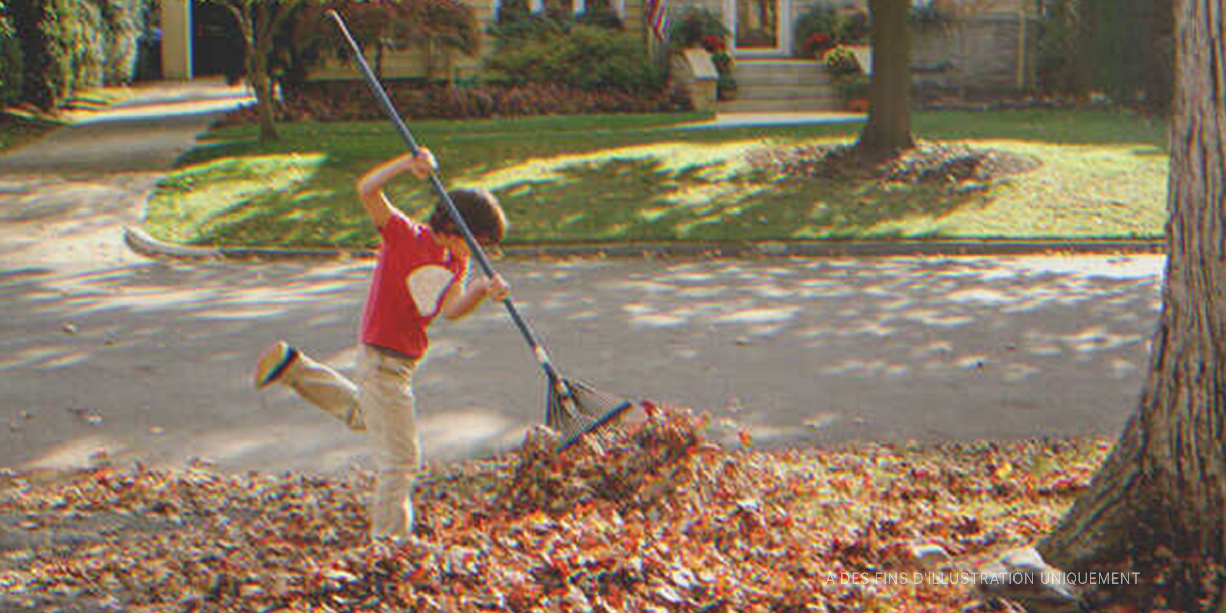 Un enfant nettoyant des feuilles mortes | Photo : Getty Images
