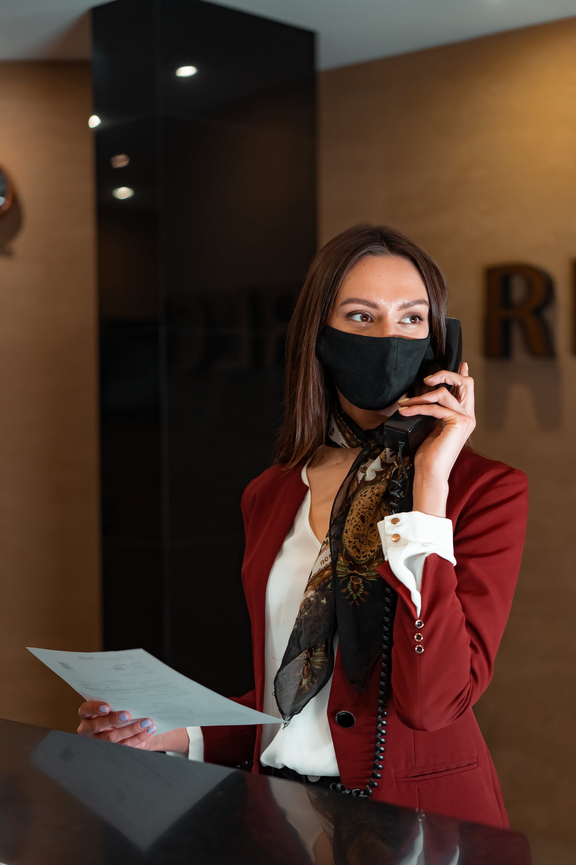 A woman talking on the phone at a hotel reception | Source: Pexels