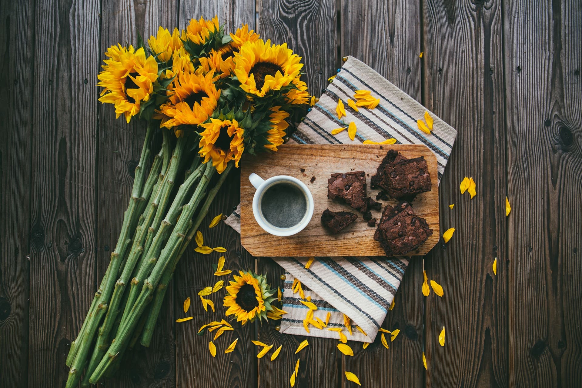 Brownies on a wooden tray with coffee and flowers on the side.  | Source: Pixabay 