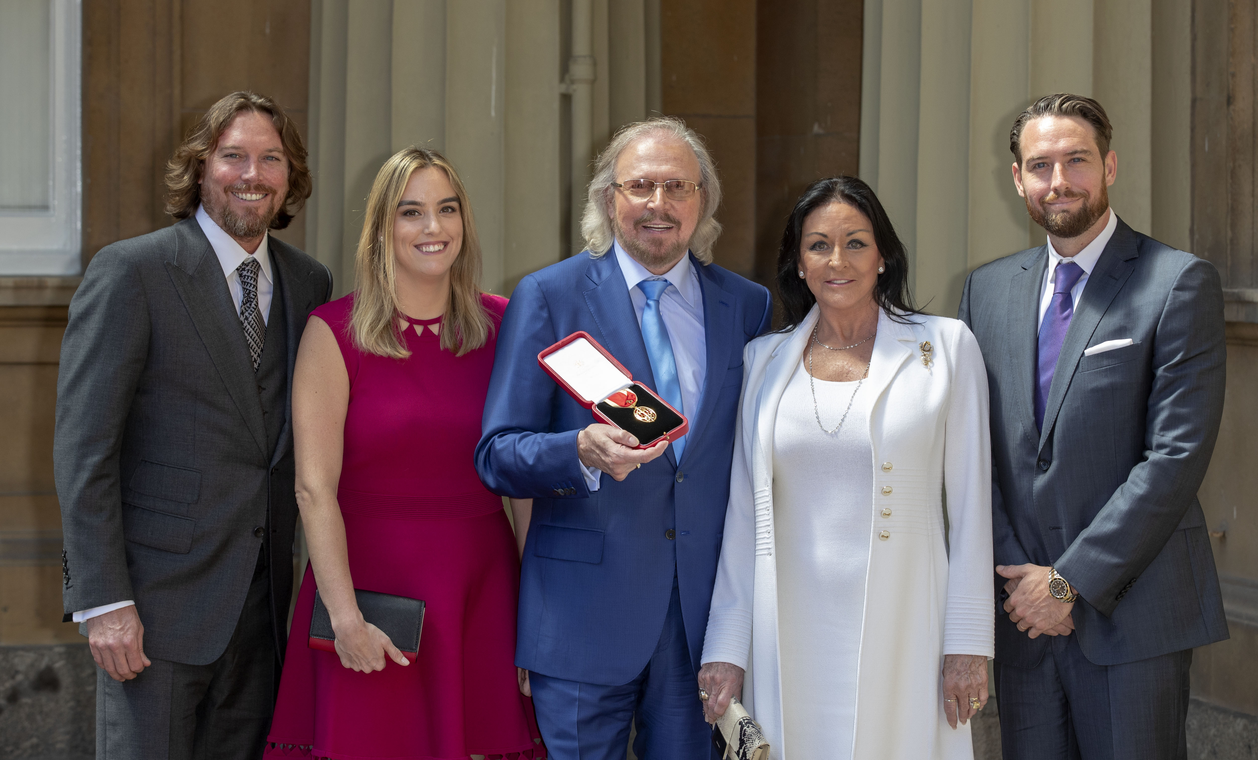 Ashley, Alexandra, and Barry Gibb with Linda Gray and Michael Gibb at Buckingham Palace in London, 2018 | Source: Getty Images