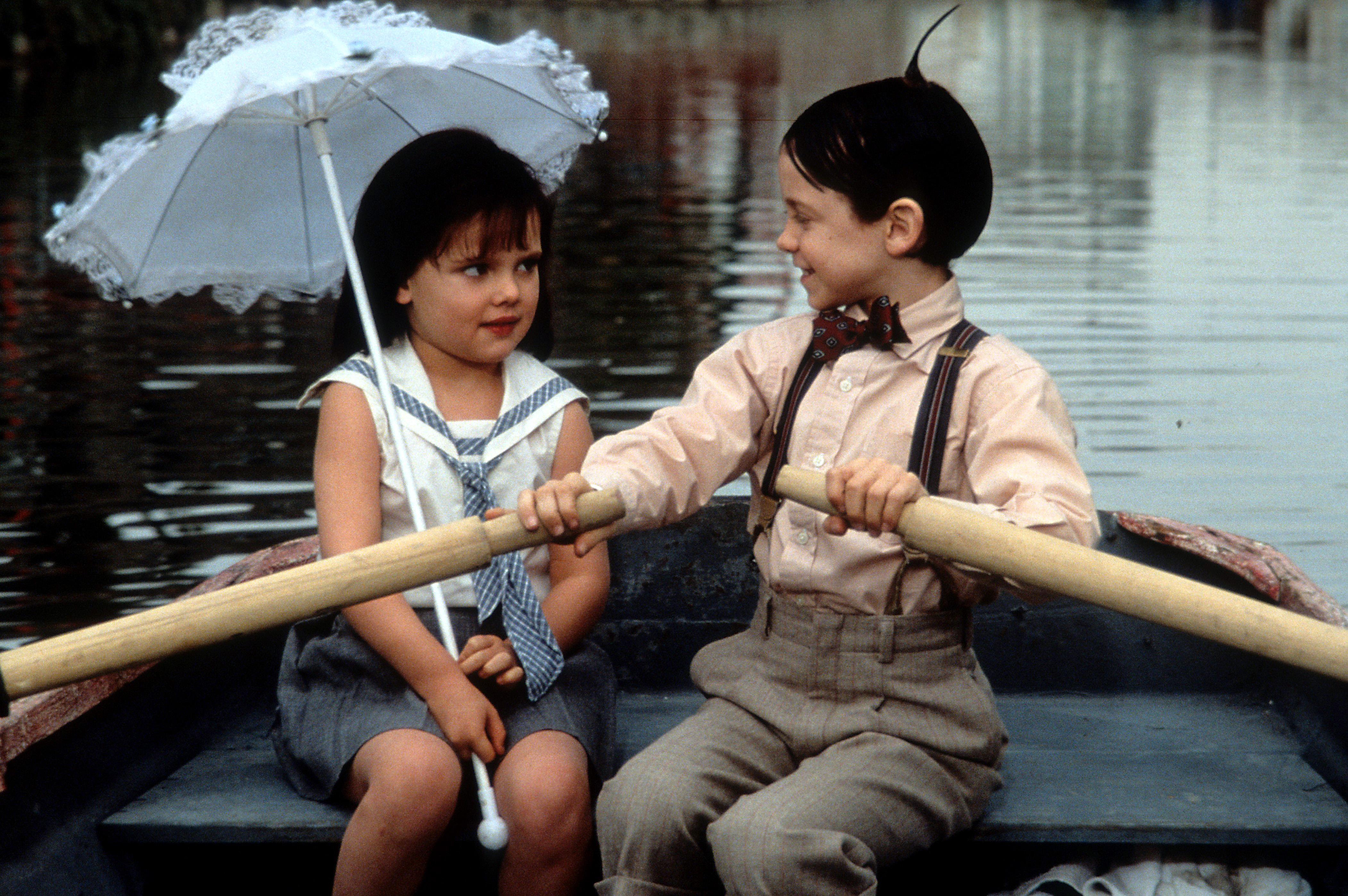 Bug Hall rowing a boat while looking at Brittany Ashton Holmes in a scene from the film "The Little Rascals" in 1994 | Source: Getty Images