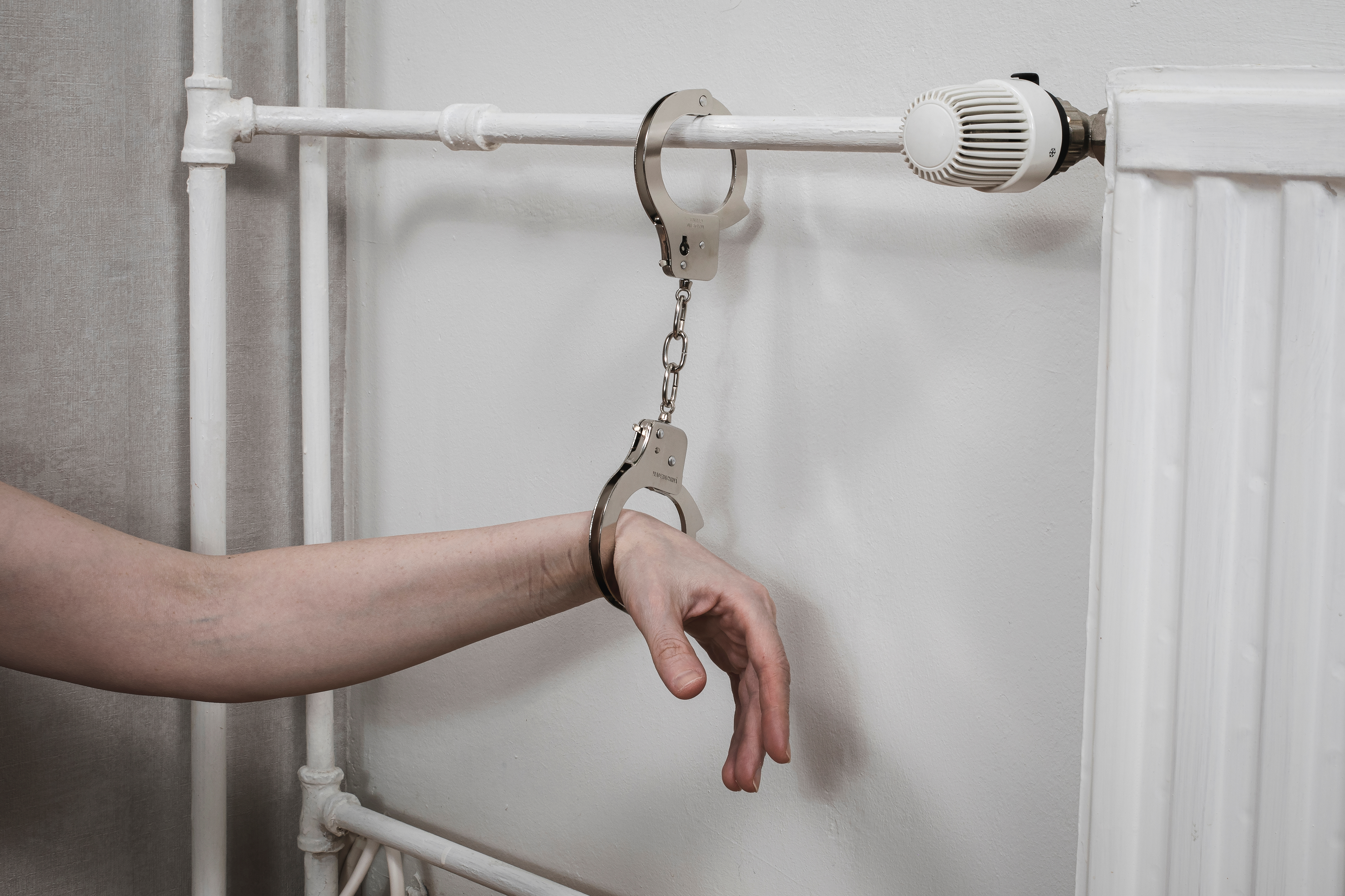 Handcuffs on the hand | Source: Shutterstock