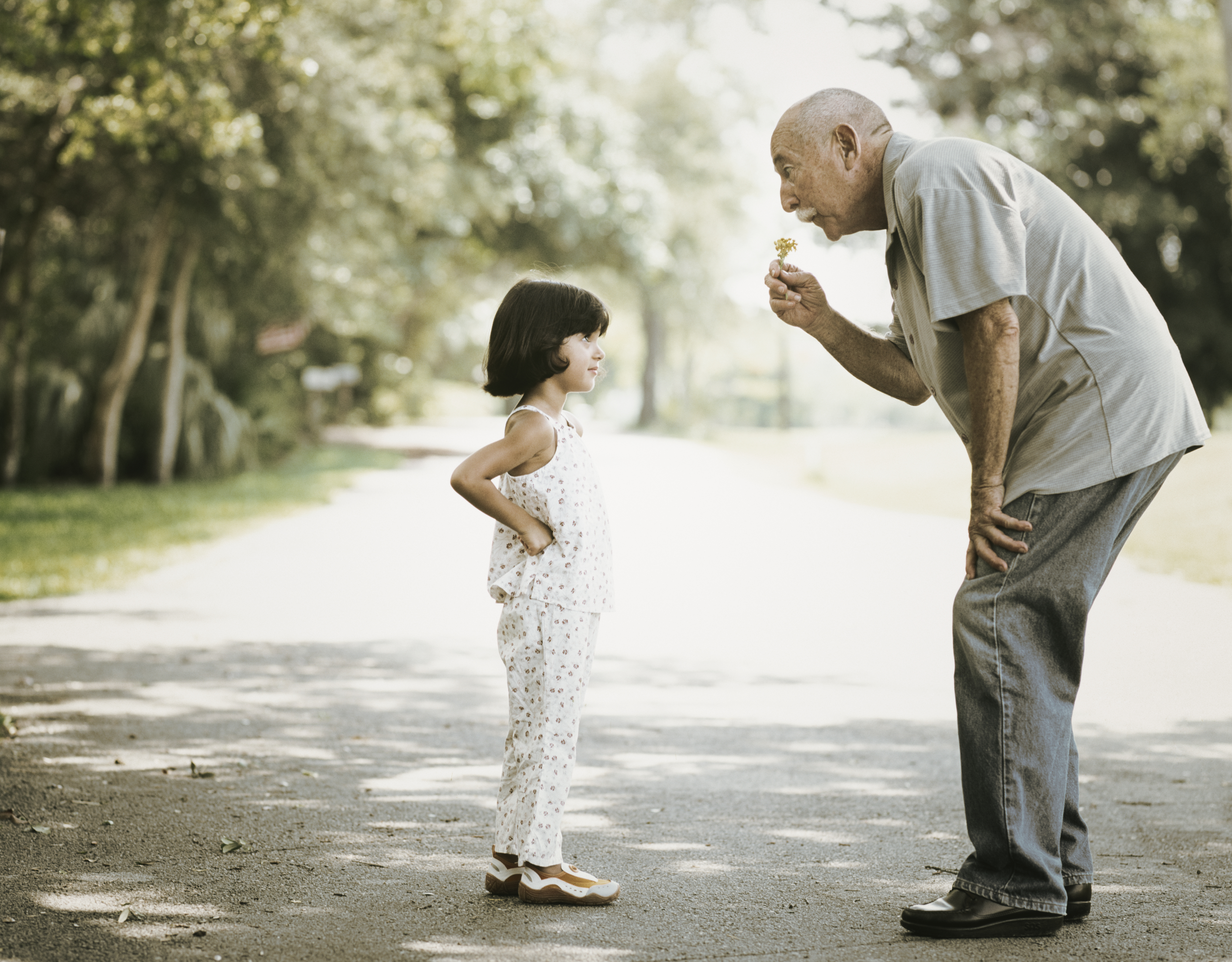 An old man giving a little girl a flower. | Source: Getty Images