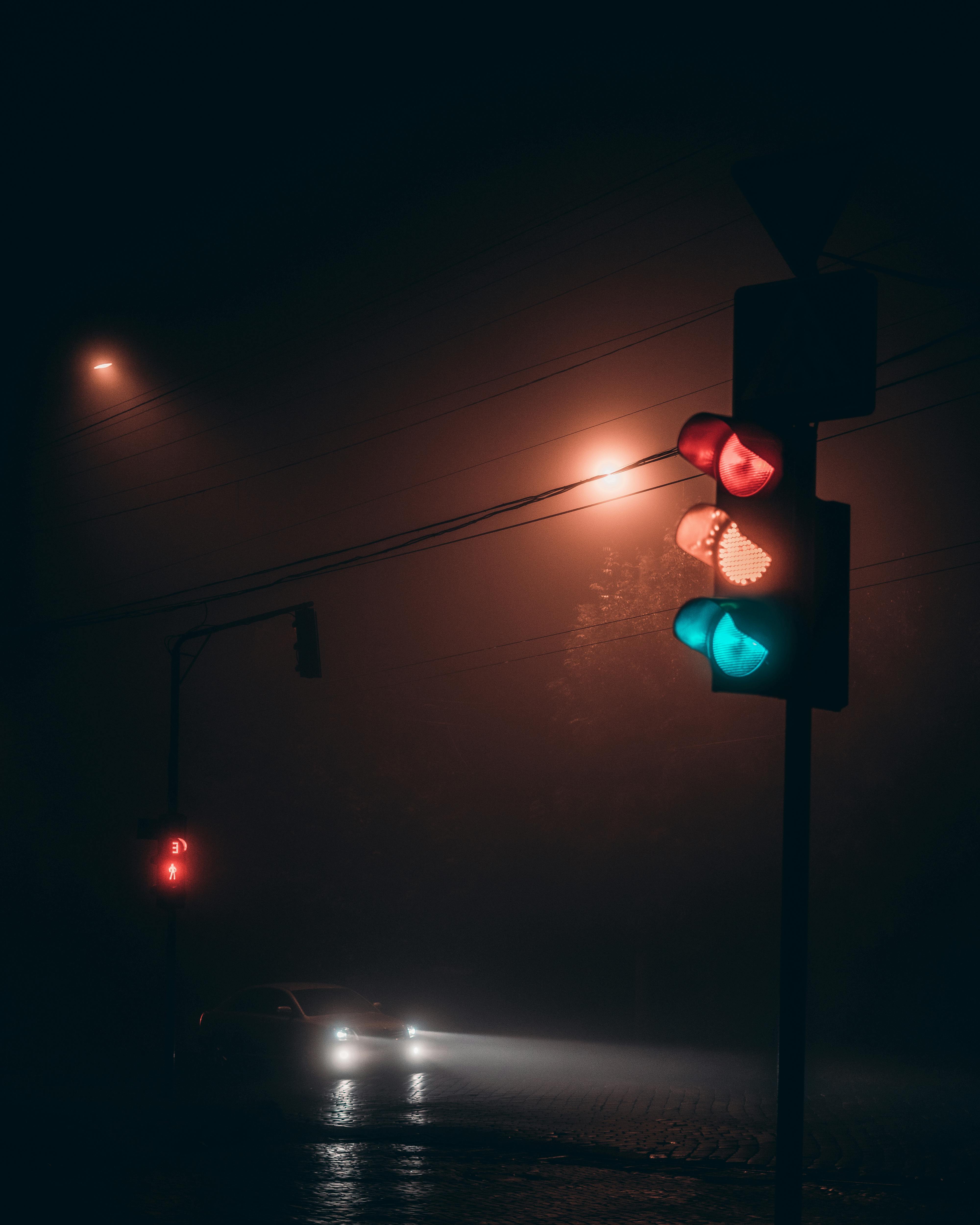 A set of overhead traffic lights shining at night | Source: Pexels