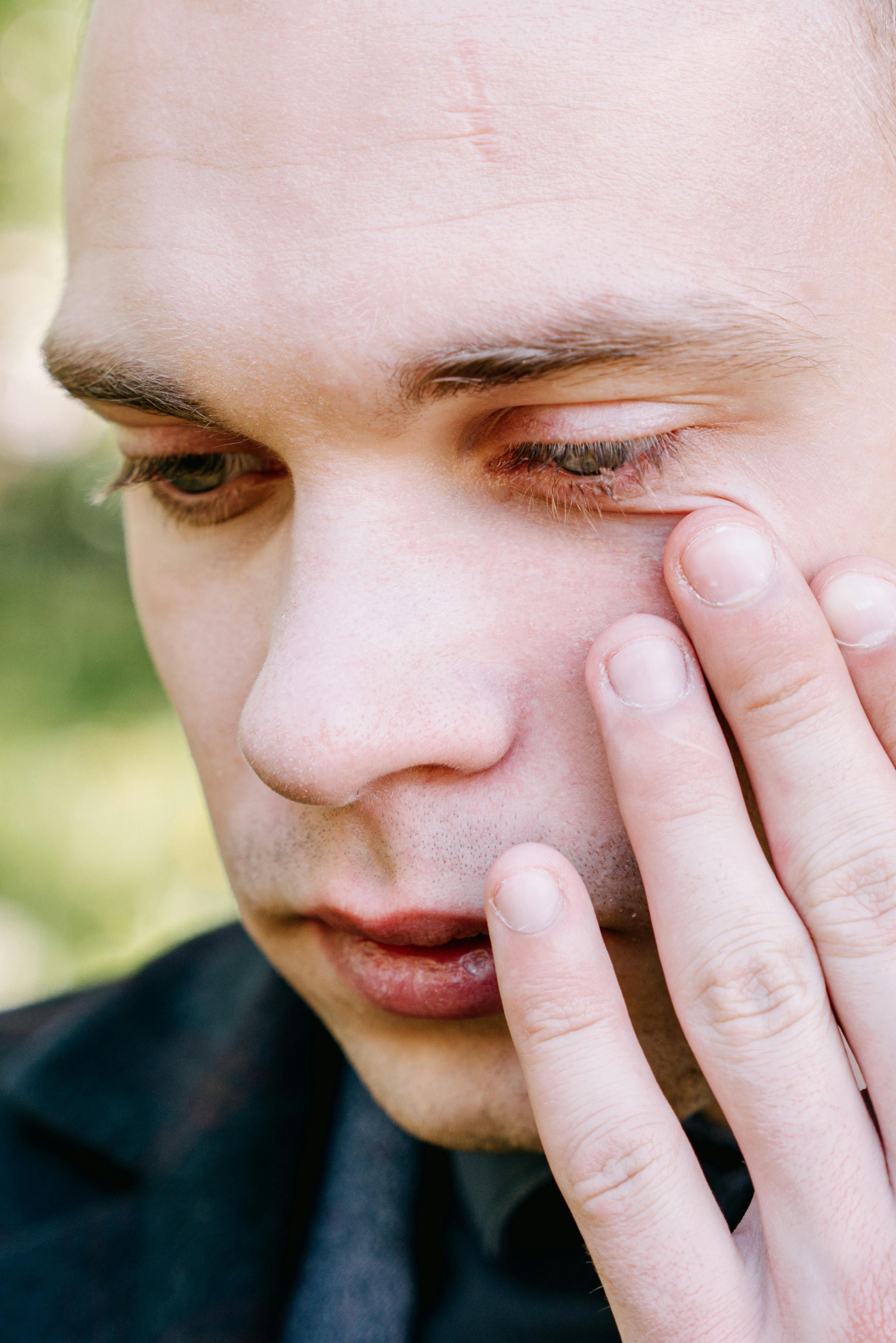 A man wiping away tears | Source: Pexels