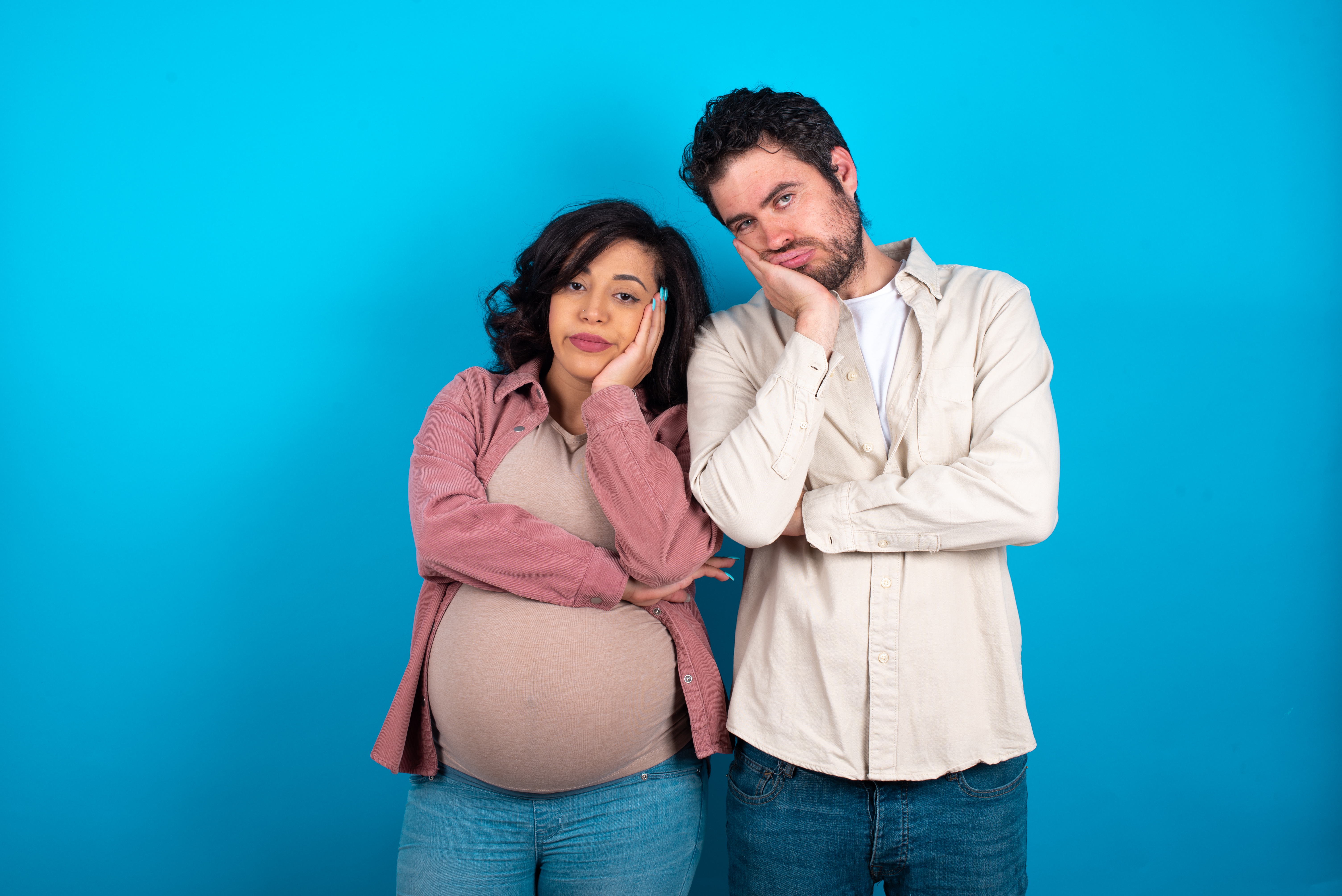 A young couple expecting a baby looks bored | Source: Shutterstock