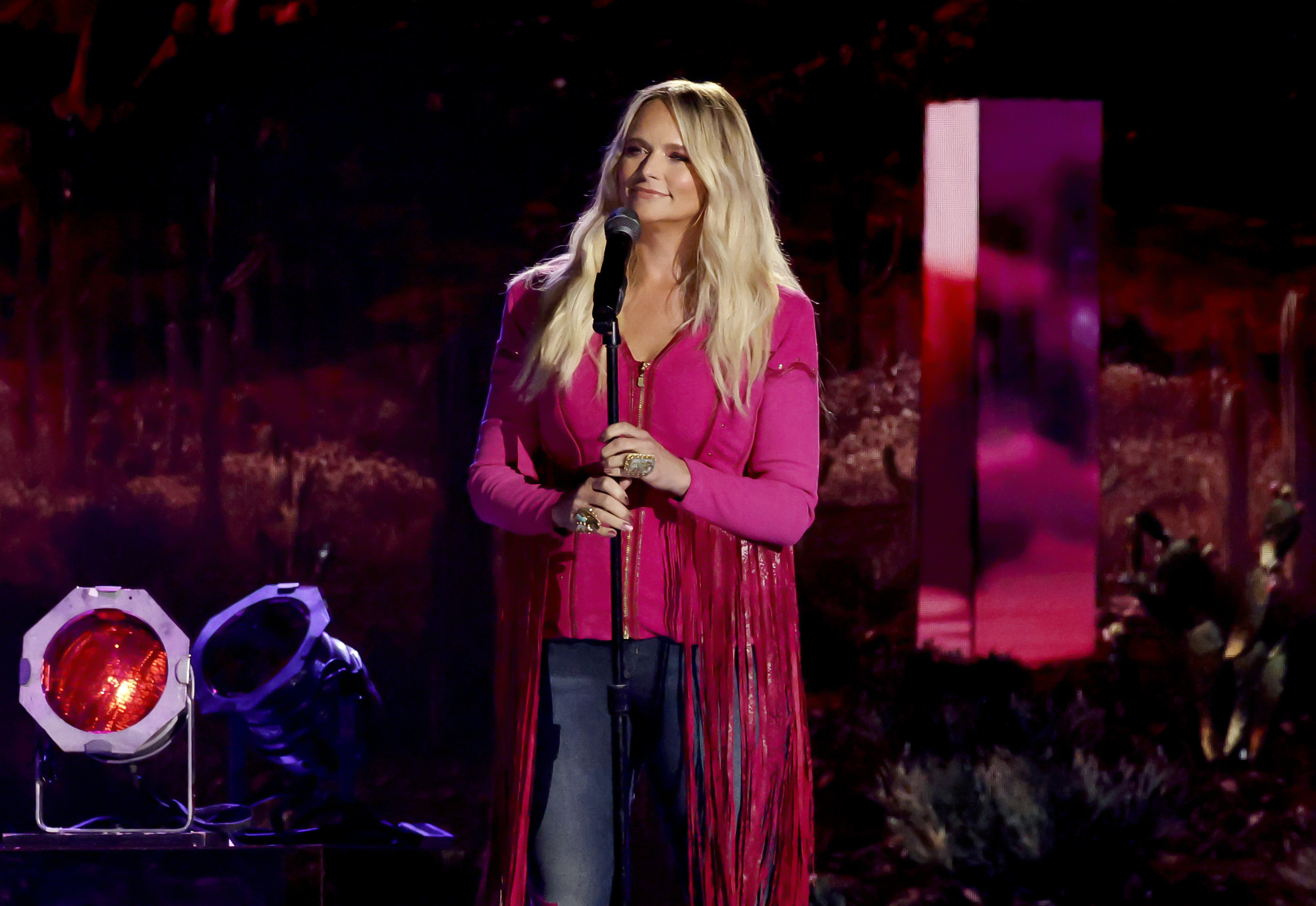 Miranda Lambert performs onstage during the 60th ACM Awards at The Star in Frisco. Dressed in a vibrant magenta fringe top and blue jeans, she delivers a powerful vocal performance while connecting with the crowd.