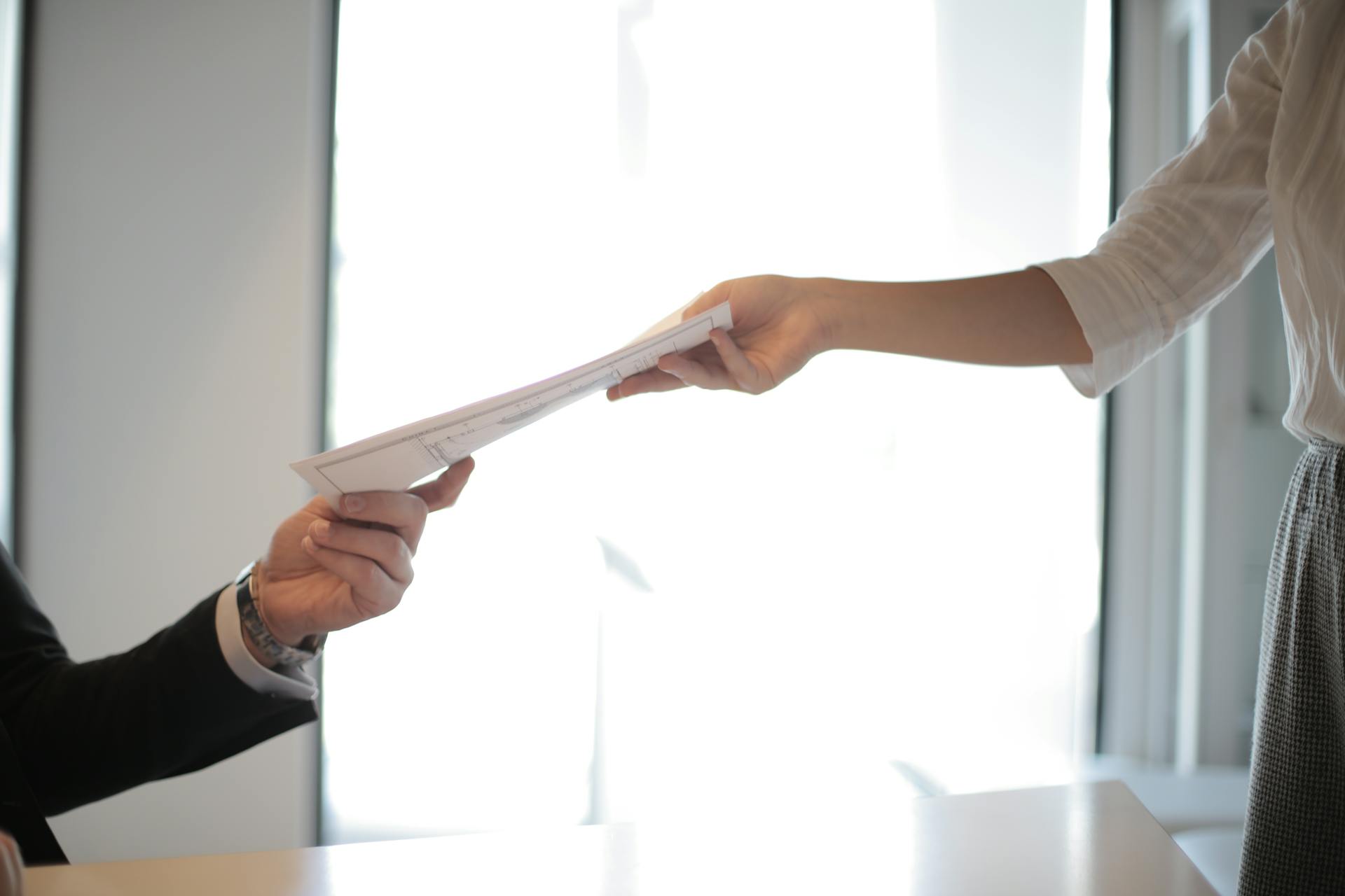 A lawyer handing documents to a woman | Source: Pexels