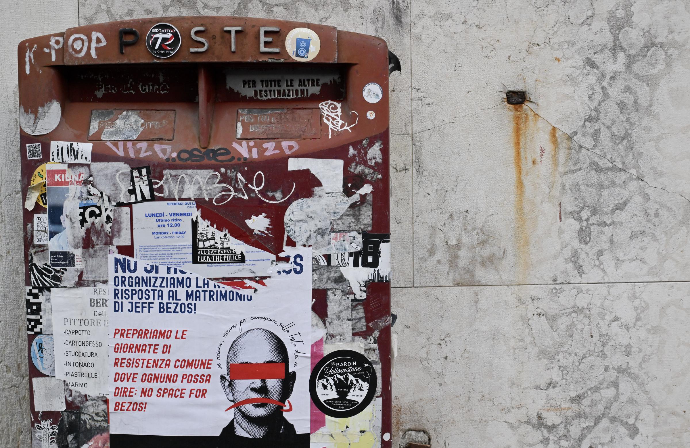 This picture taken on June 24, 2025 shows a poster calling for a protest against Bezos' wedding pasted on a mail box in Venice, northern Italy. | Source: Getty Images