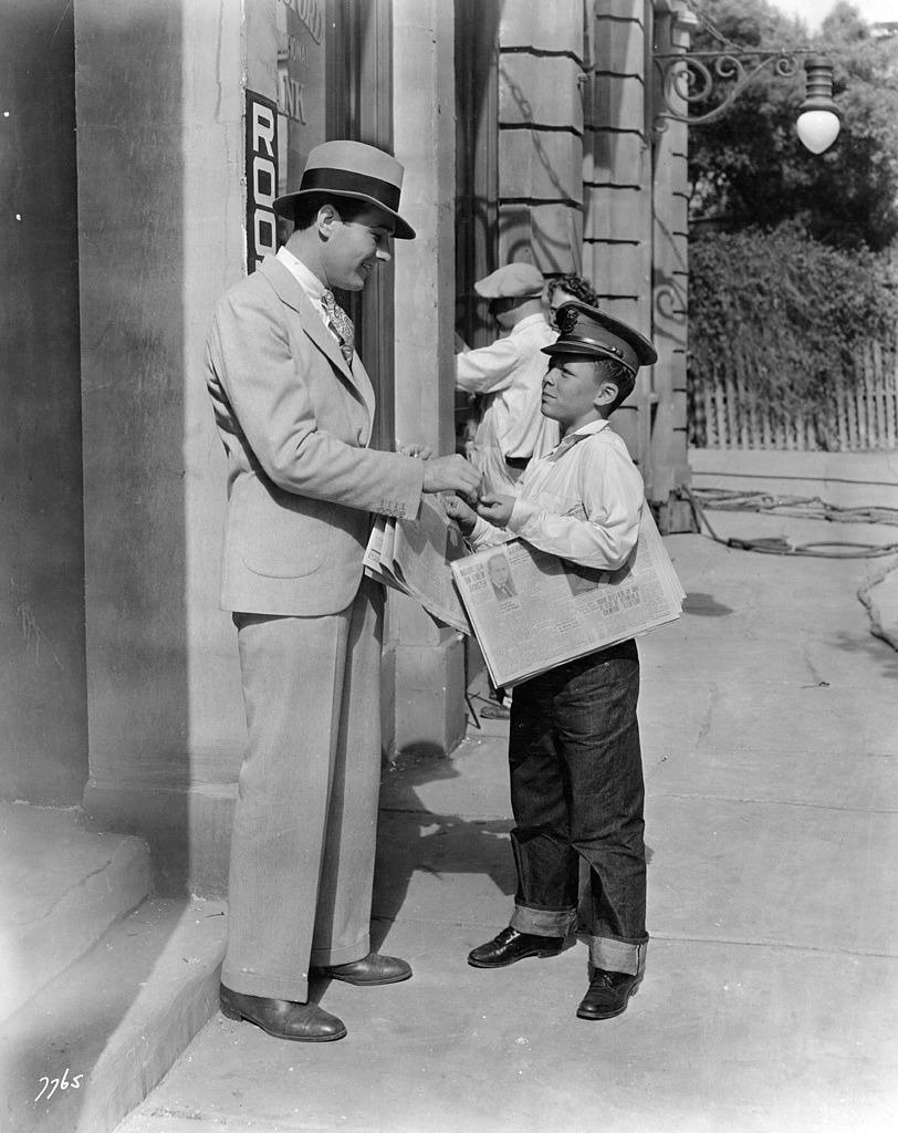 William Haines the film actor, buys a paper from 'The Major' (Carl Rupp) on the MGM studio lot, circa 1927 | Photo: Getty Images