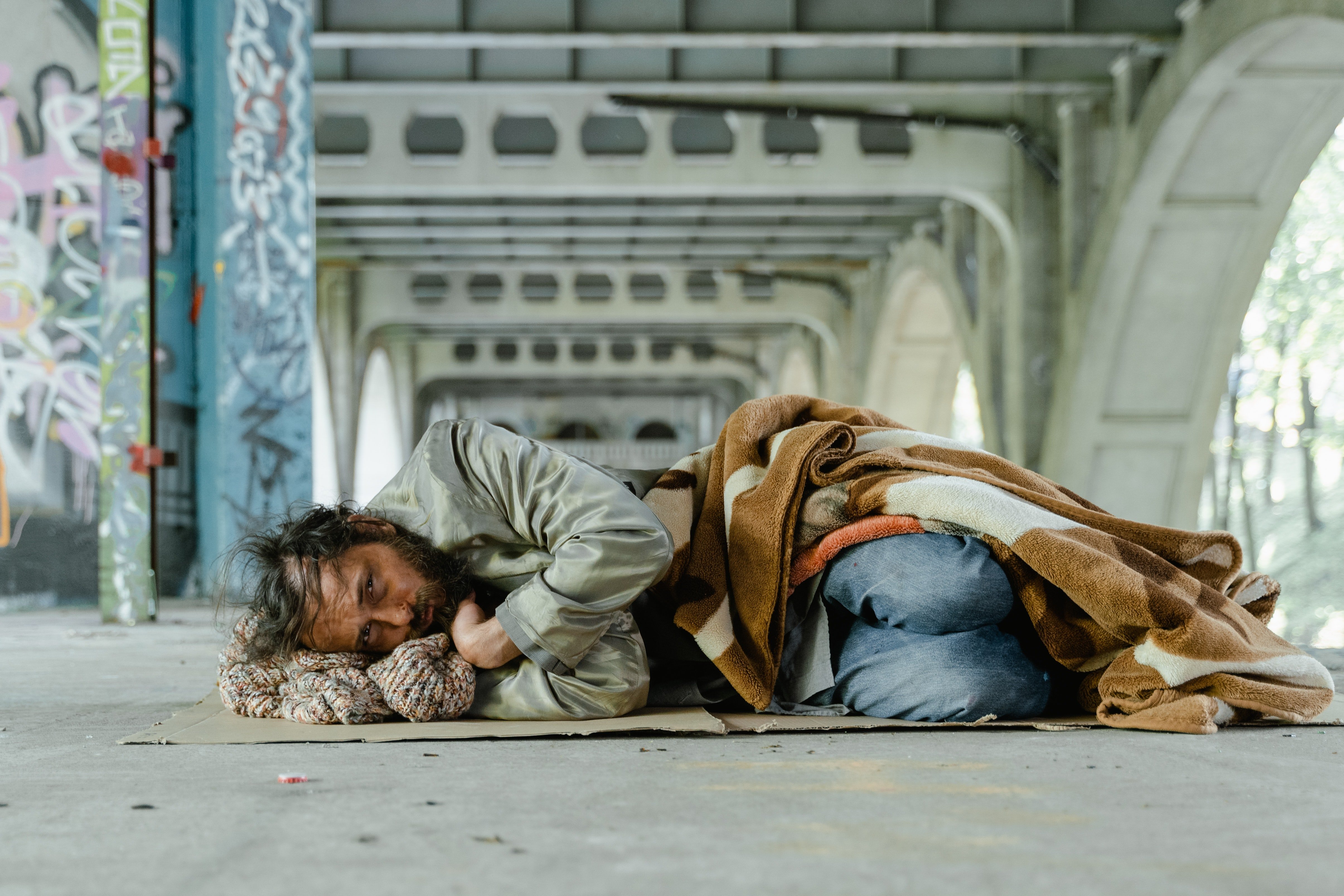 Hombre sin hogar recostado sobre el suelo. | Foto: Pexels
