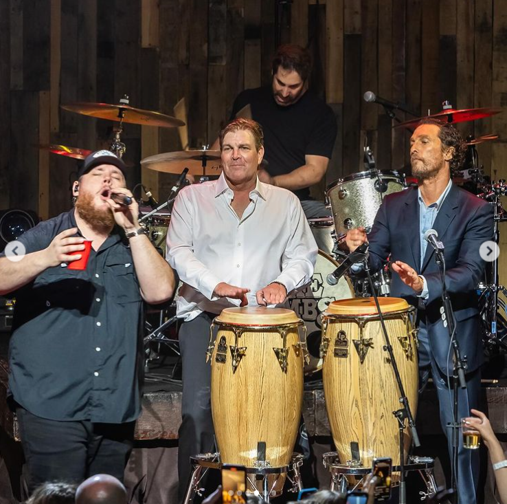 Luke Combs and Matthew McConaughey sing onstage with a band, in a photo shared on Instagram in April 2024. | Source: Instagram/officiallymcconaughey