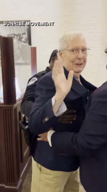 Senator Mitch McConnell briefly waves while being assisted by a Capitol Police officer and an aide, as posted on October 16, 2025 | Source: YouTube/WHAS11News