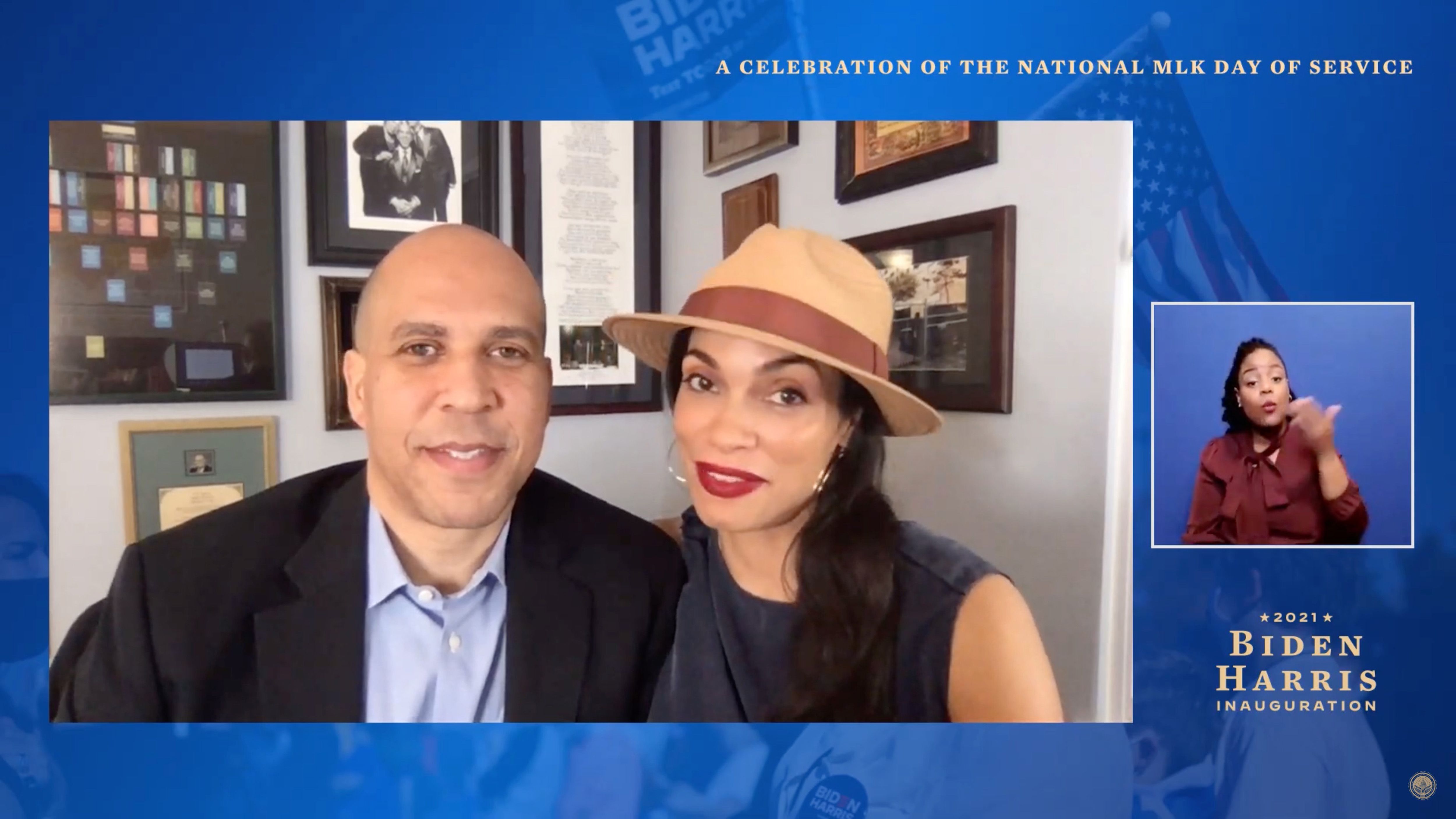 In a virtual appearance for the National MLK Day of Service, Cory Booker and Rosario Dawson sit side by side — he in a suit, she in a hat — smiling as they speak about unity and service from home.