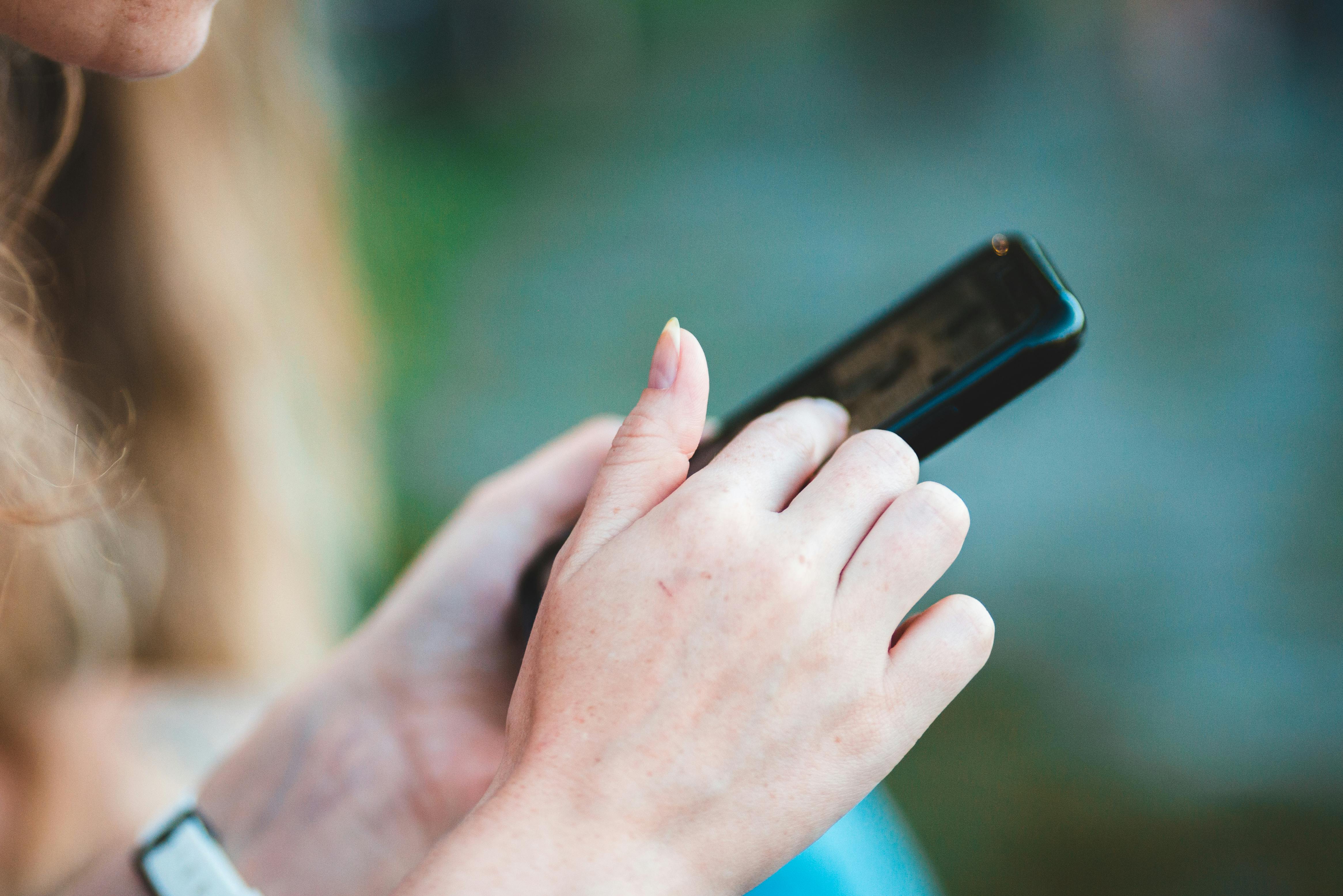 A woman typing on her phone | Source: Pexels