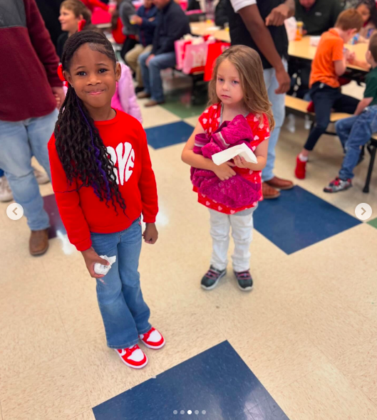 R'Mani and her little friend posing for a photo during a Valentine's Day celebration surrounded by other kids, posted on February 13, 2025. | Source: Instagram/hoodfamelilronnie