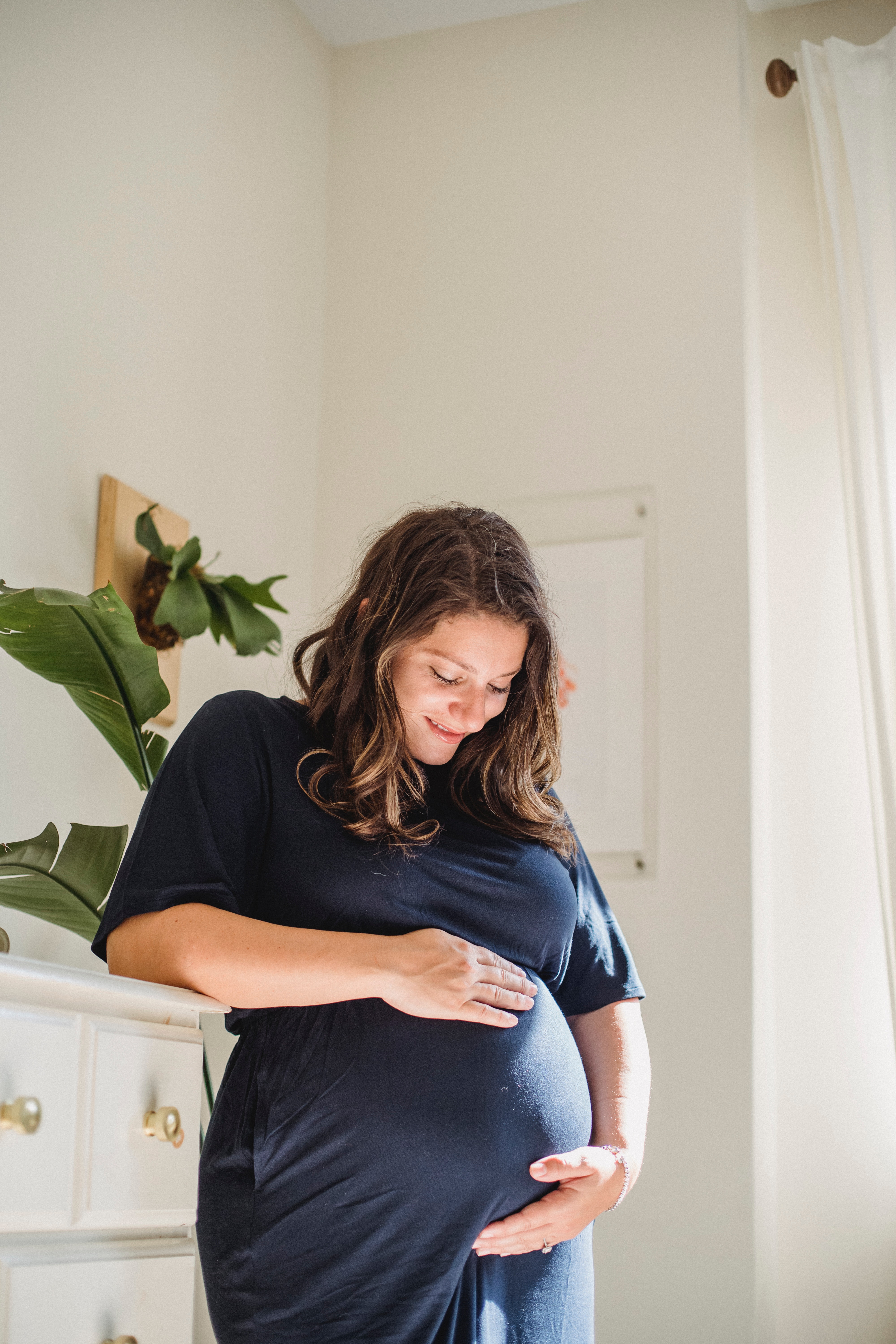 A woman smiling at her pregnant belly | Source: Pexels