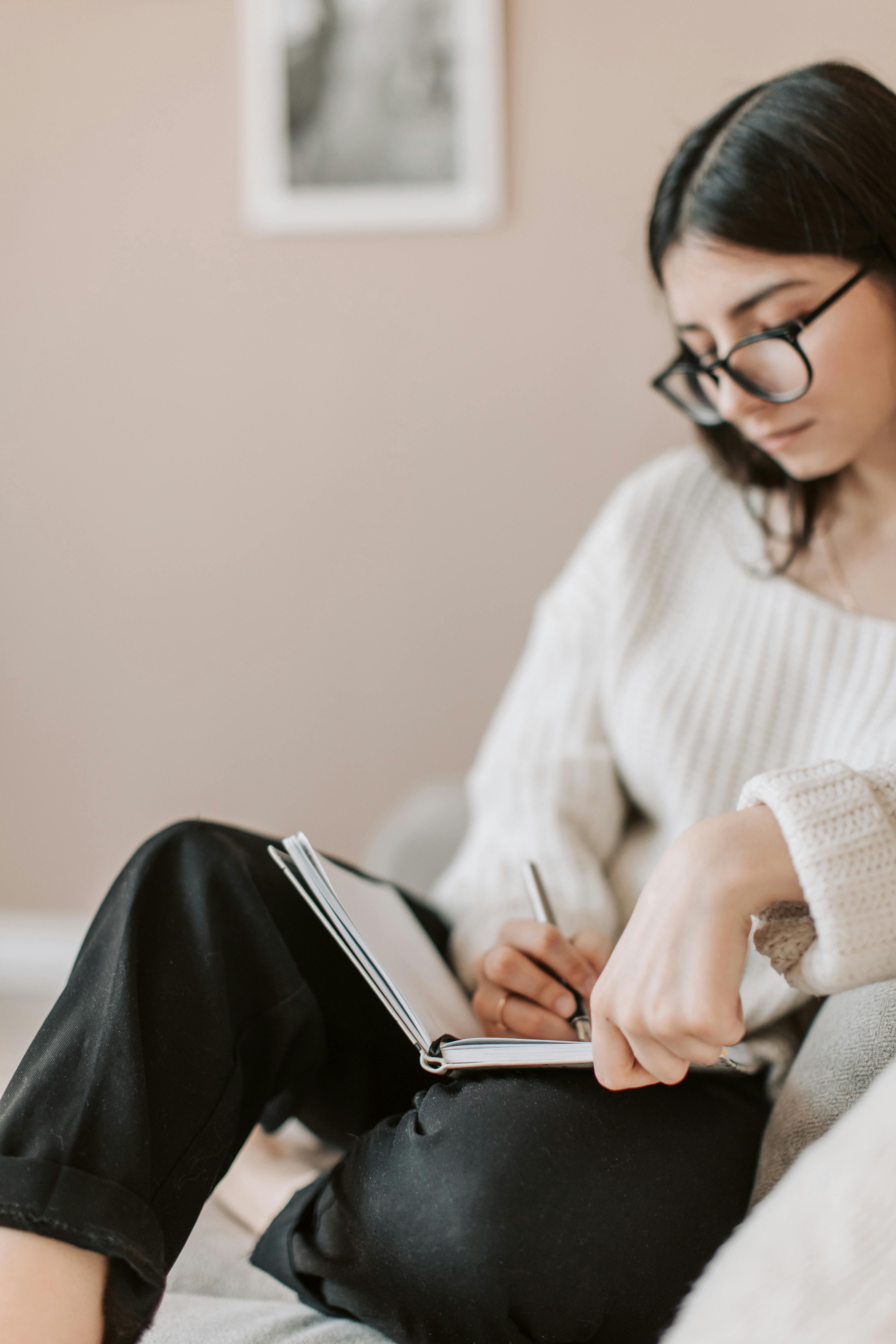 A woman writing in a journal | Source: Pexels