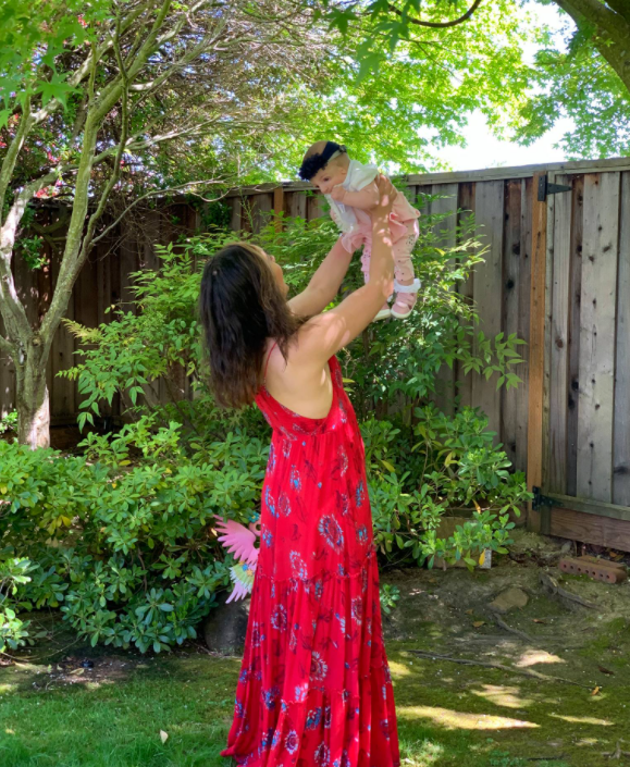  Eliza Jamkochian Bahneman holding her baby Isabella up in the air. │Source: facebook.com/elizabeth.jamkochian