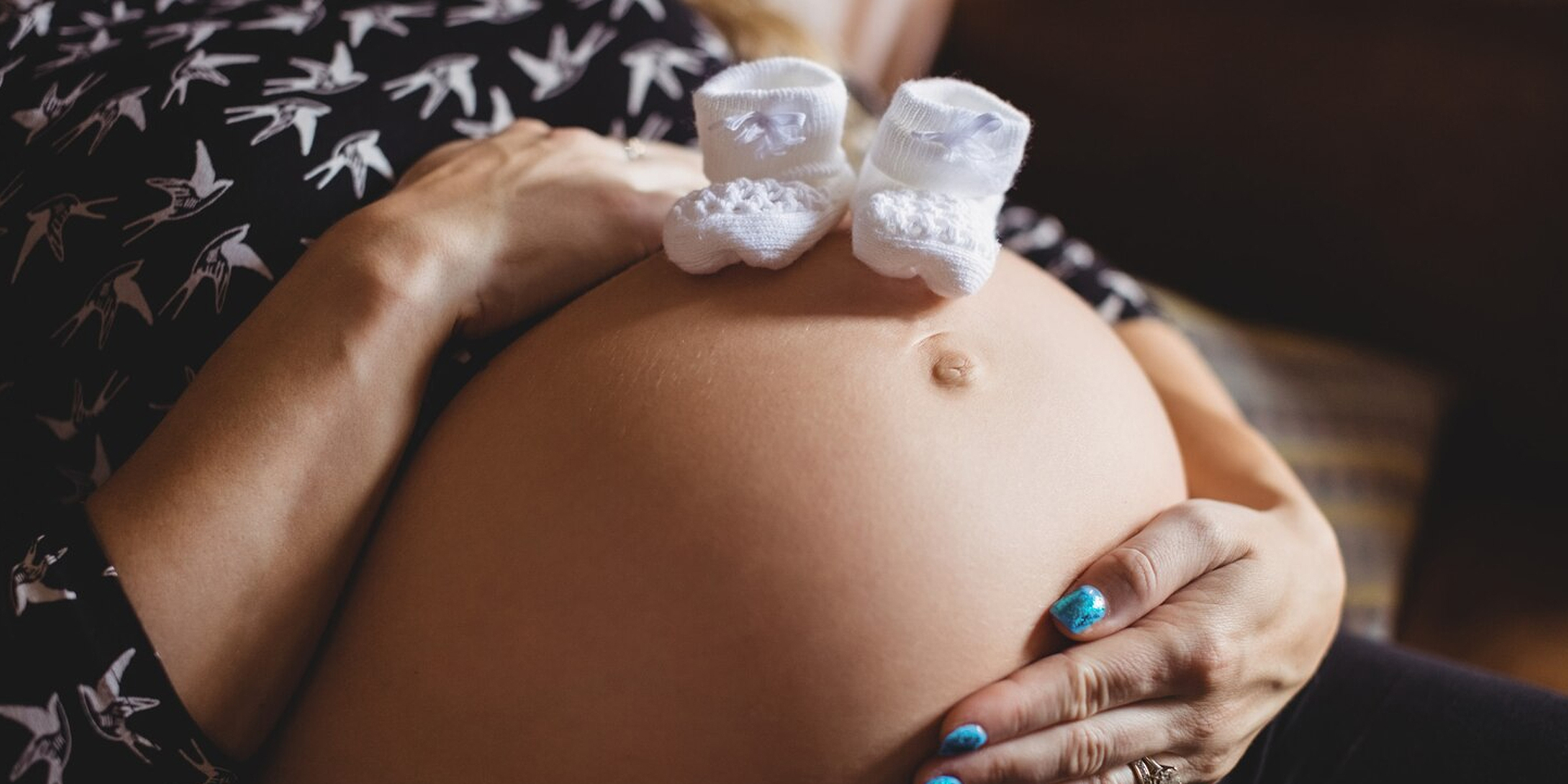 A pregnant woman holding her belly | Source: Freepik