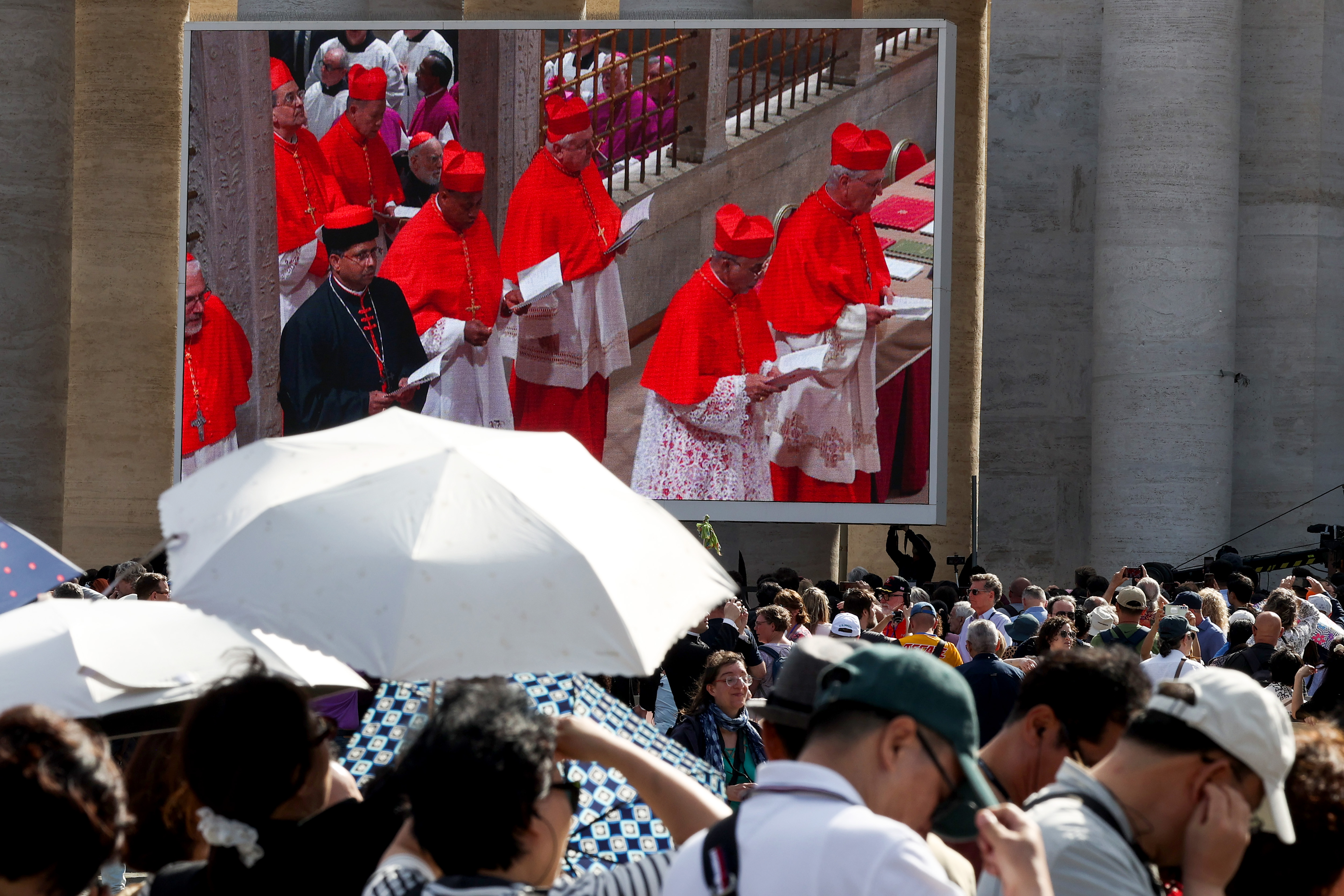 Cardinals enter the Sistine Chapel for the conclave, shown on screens at St. Peter's Square in Vatican City on May 7, 2025 | Source: Getty Images