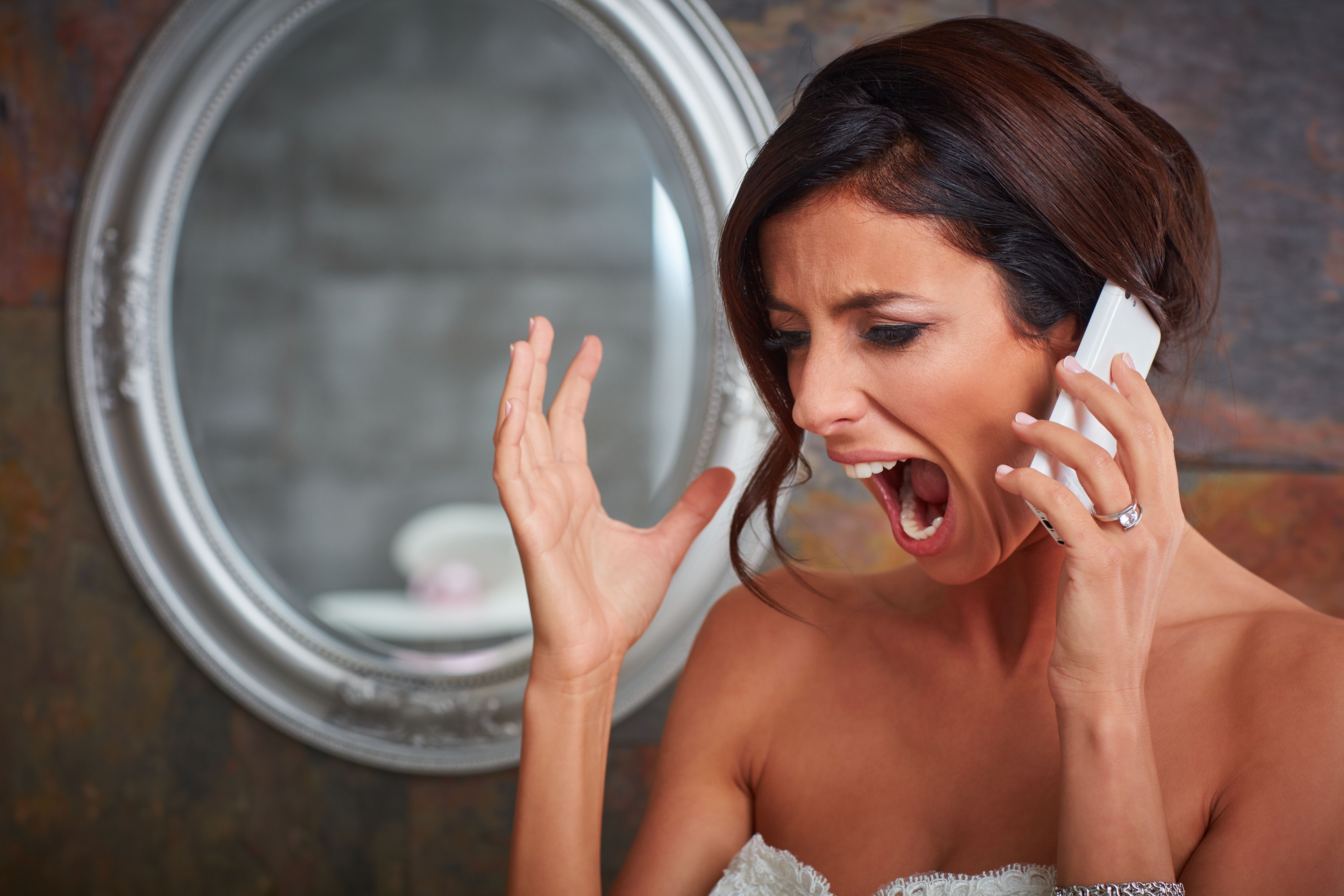 A bride shouting on the phone | Source: Shutterstock