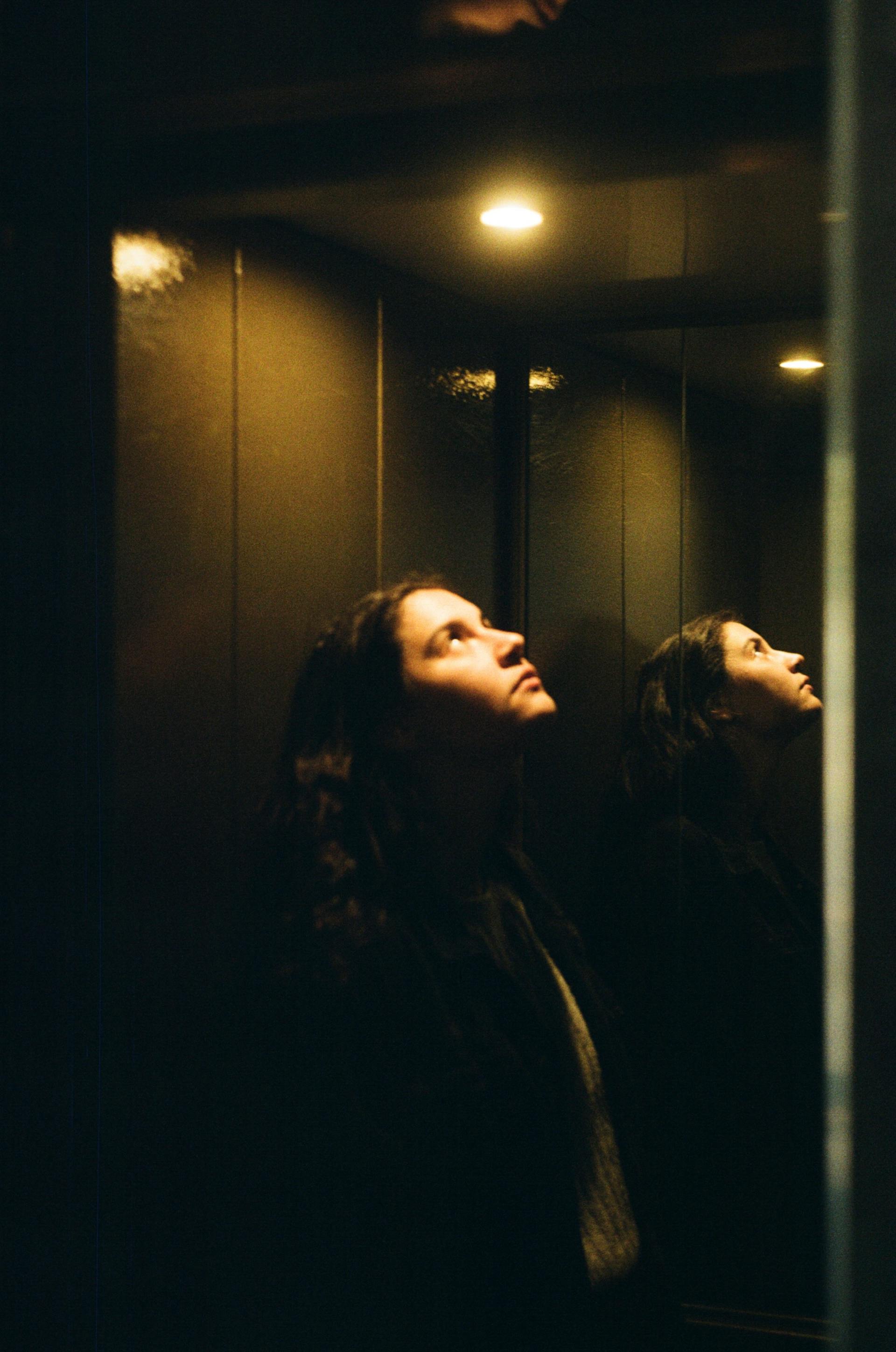 A woman in an elevator looking at the light | Source: Pexels