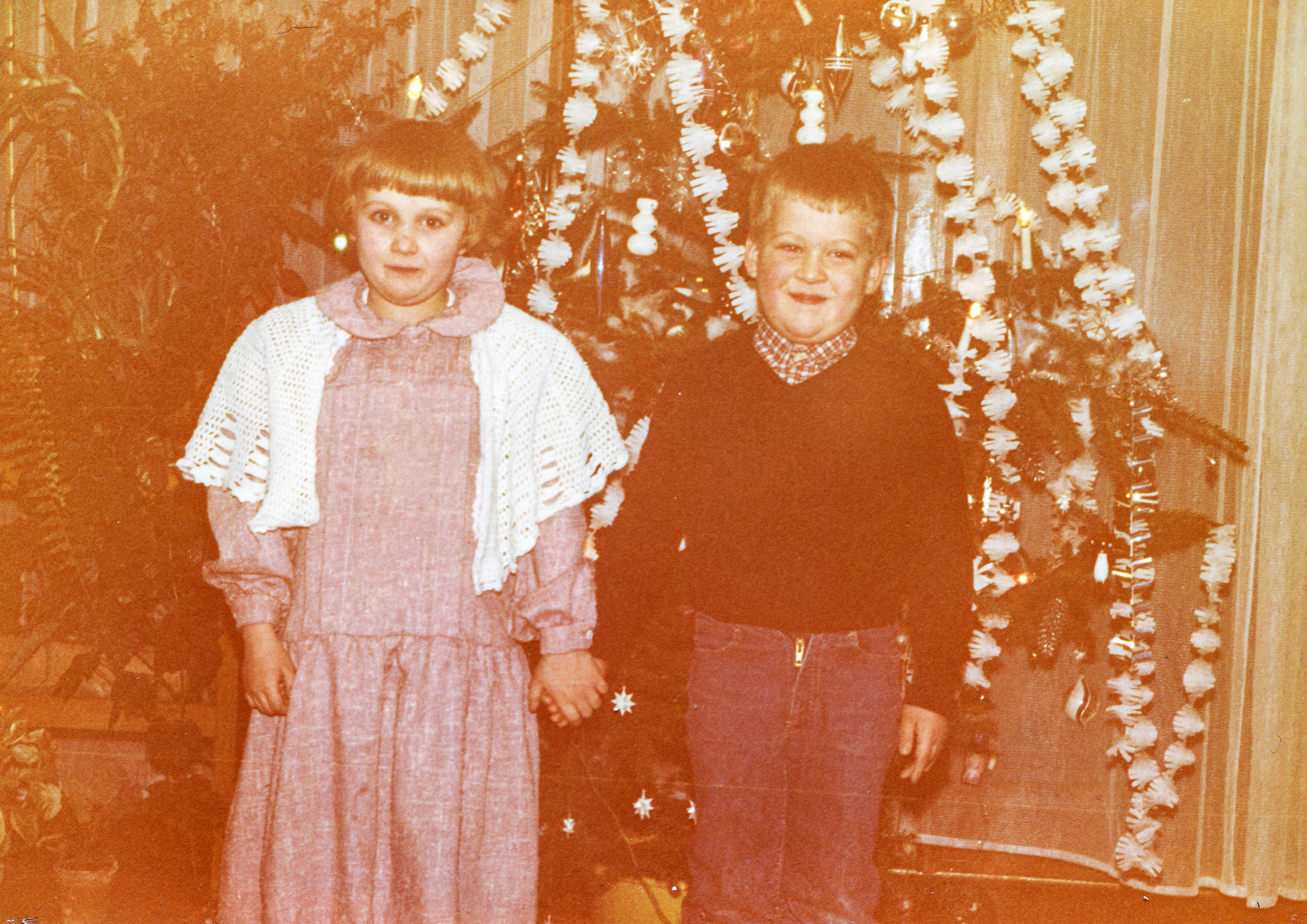 Vintage photo of children near Christmas tree, early eighties | Source: Shutterstock
