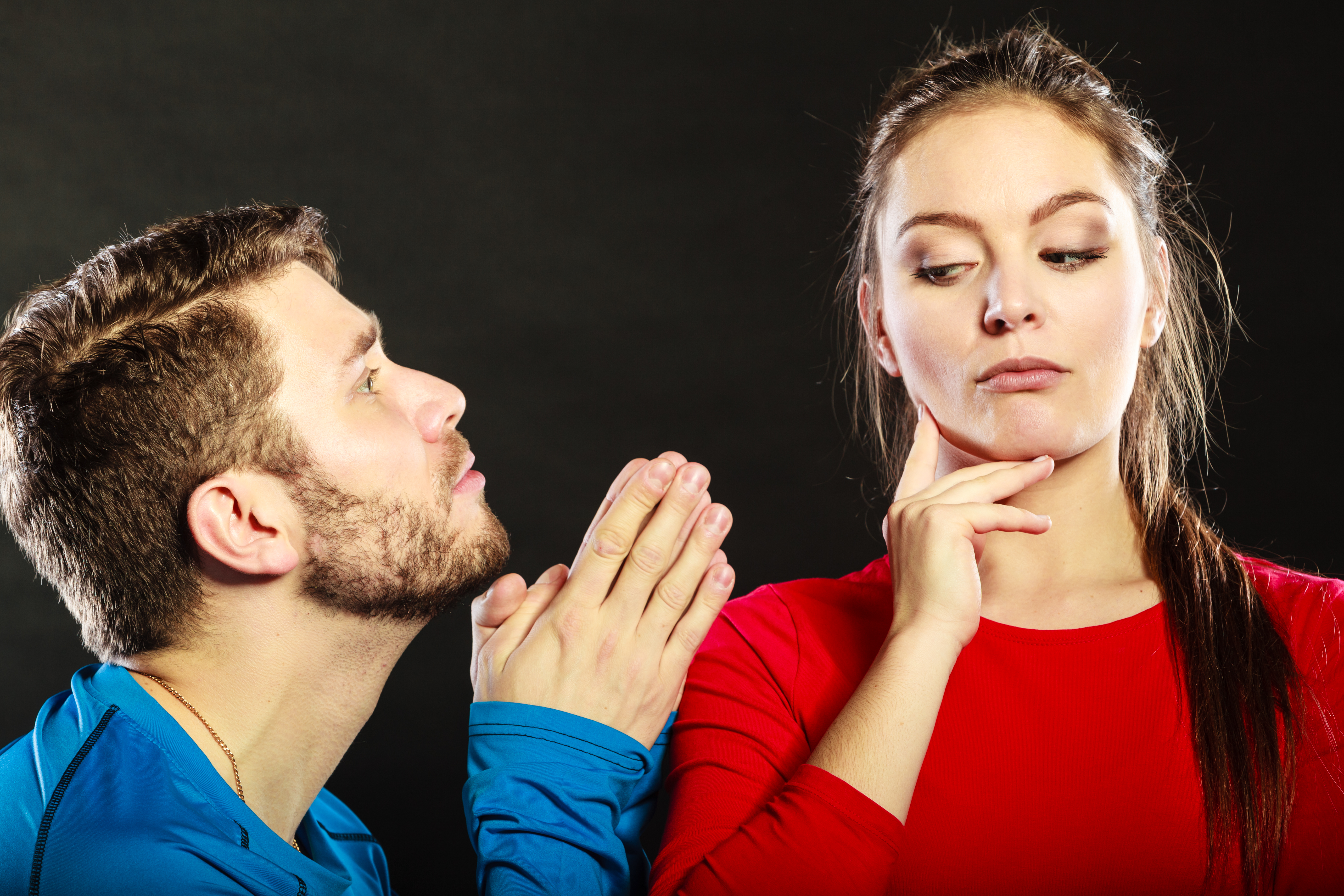 A man begging an unrelenting woman | Source: Getty Images