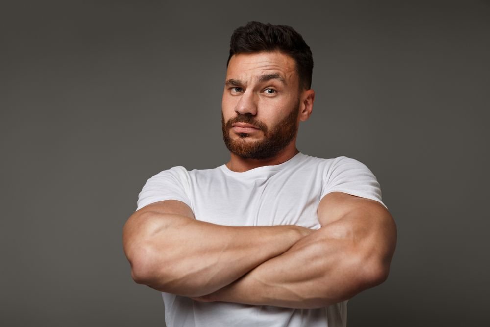 A man looks angry with his arms crossed. | Source: Shutterstock