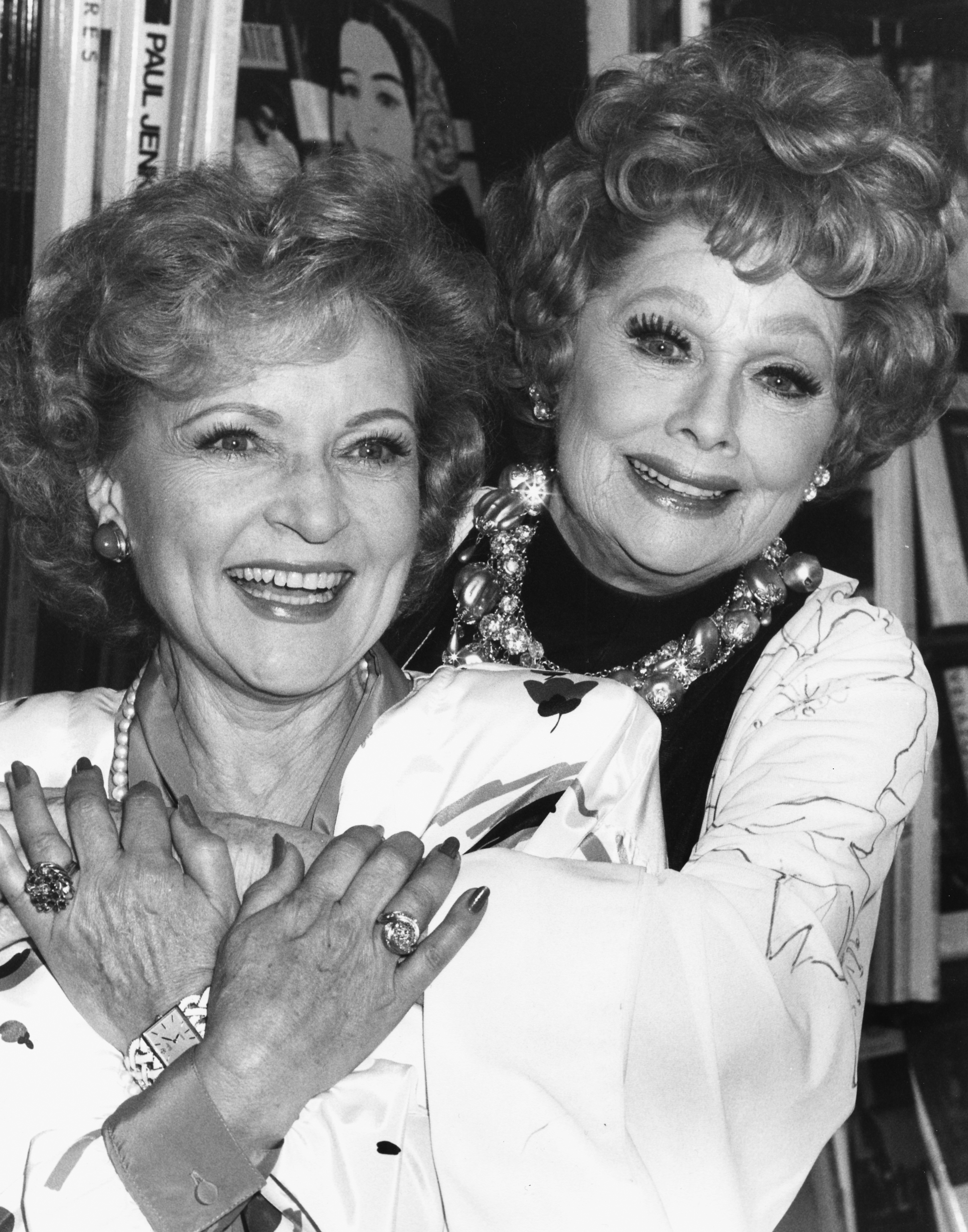 Betty White and Lucille Ball embracing at a book signing event on October 2 1987, in Los Angeles, California. | Source: Getty Images