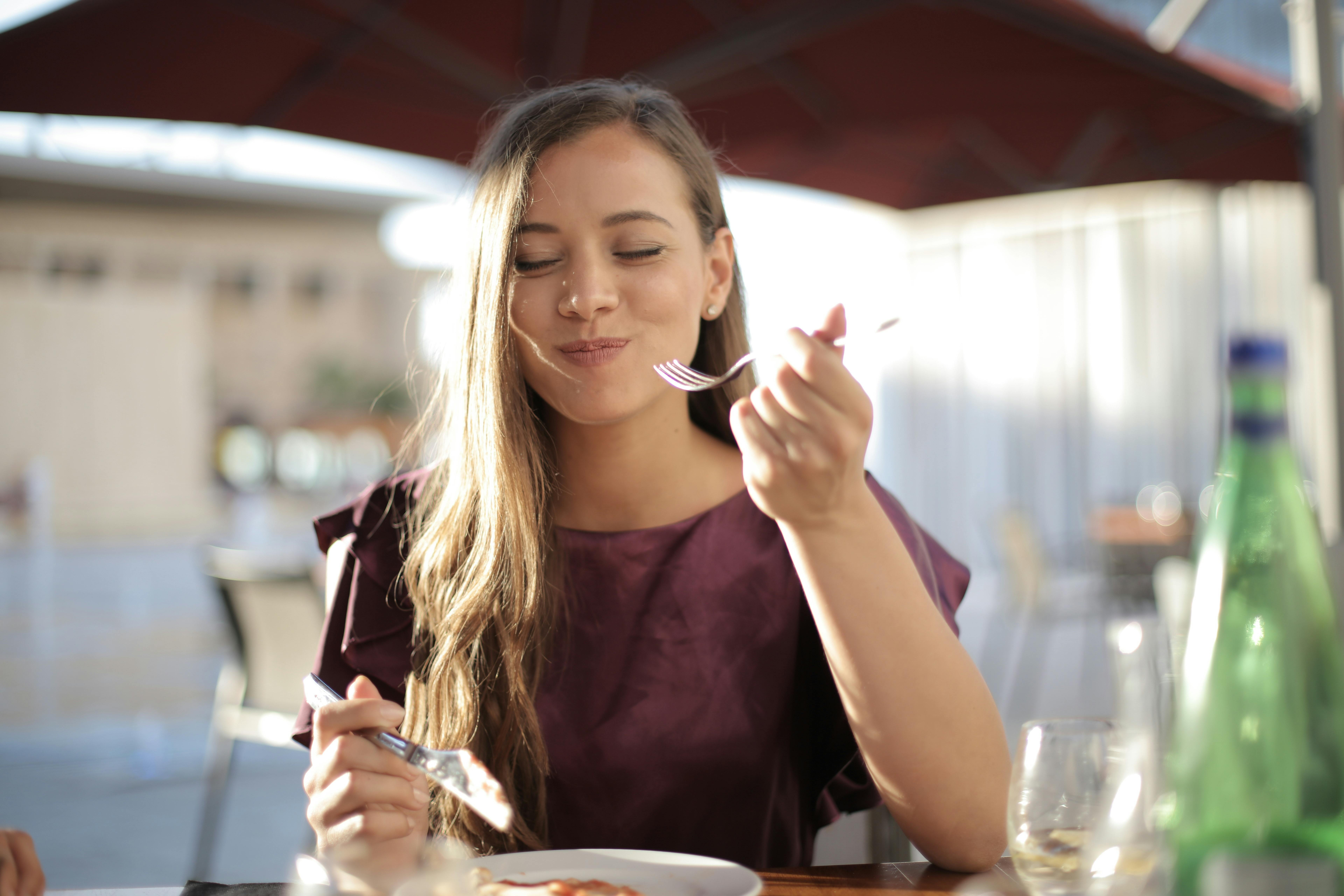 A woman enjoying a meal. | Source: Pexels