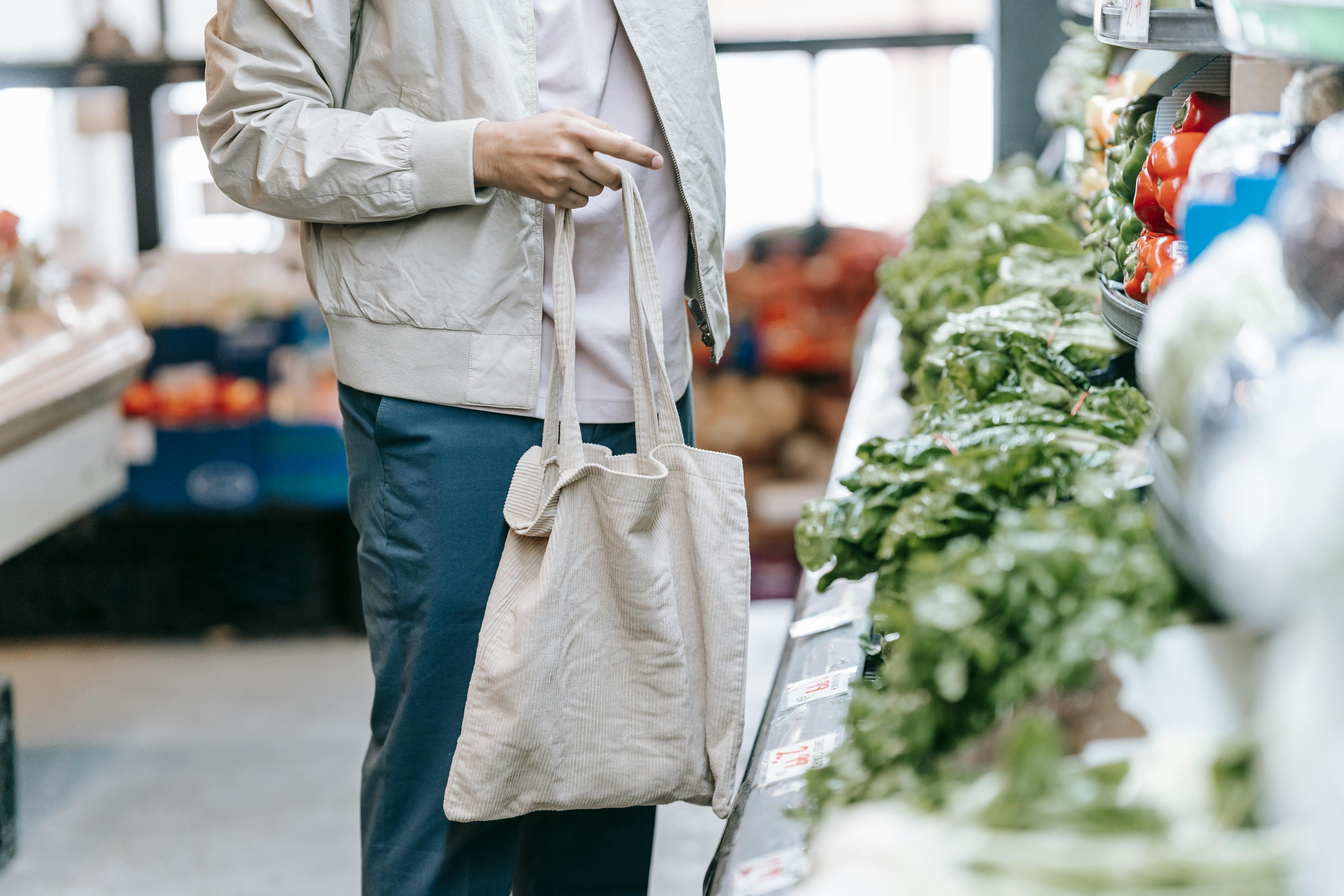 A man holding a shopping back at a grocery store | Source: Pexels