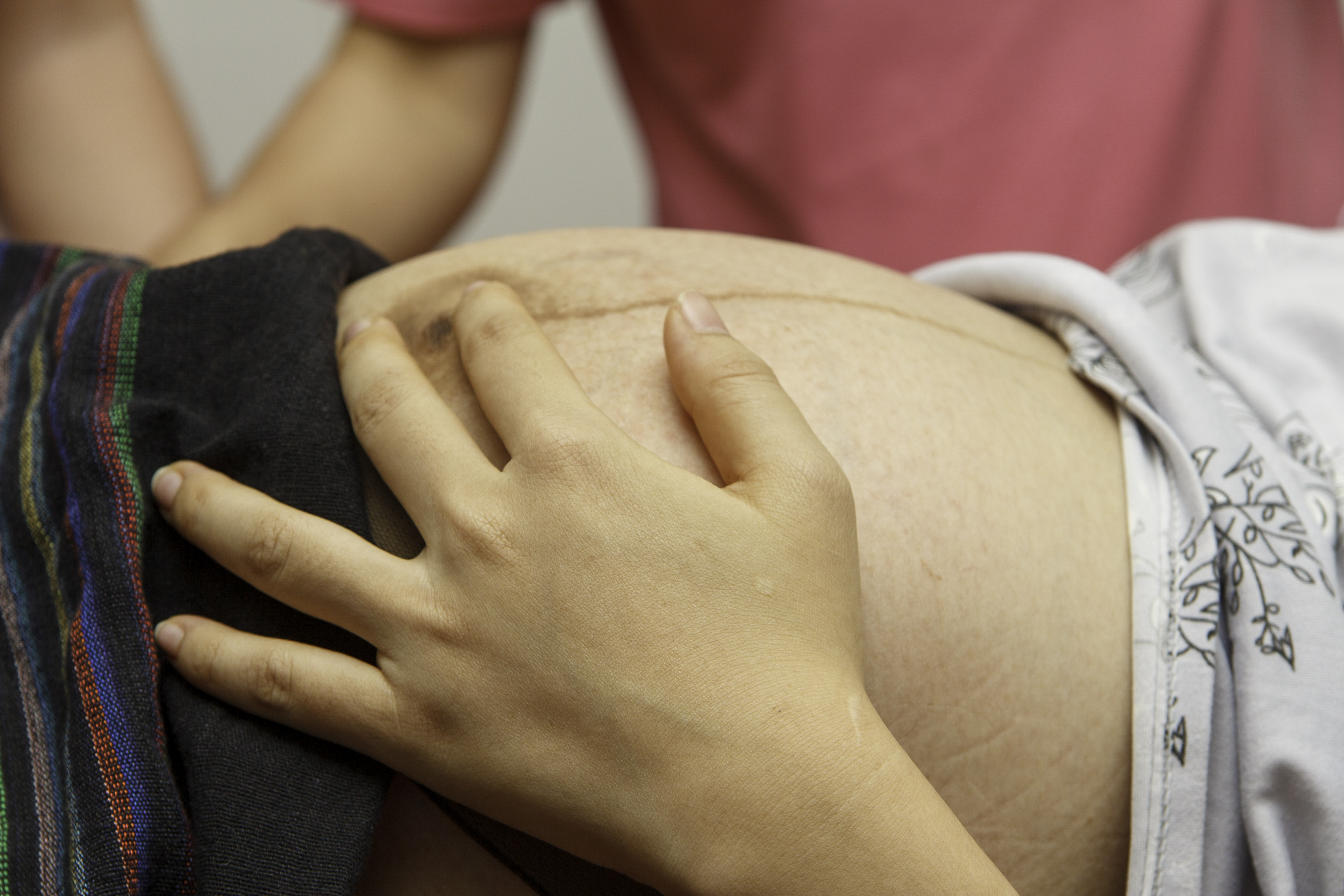 A pregnant woman holding her belly in the delivery room at the Luang Prabang Provincial Hospital on June 20, 2023 | Source: Getty Images