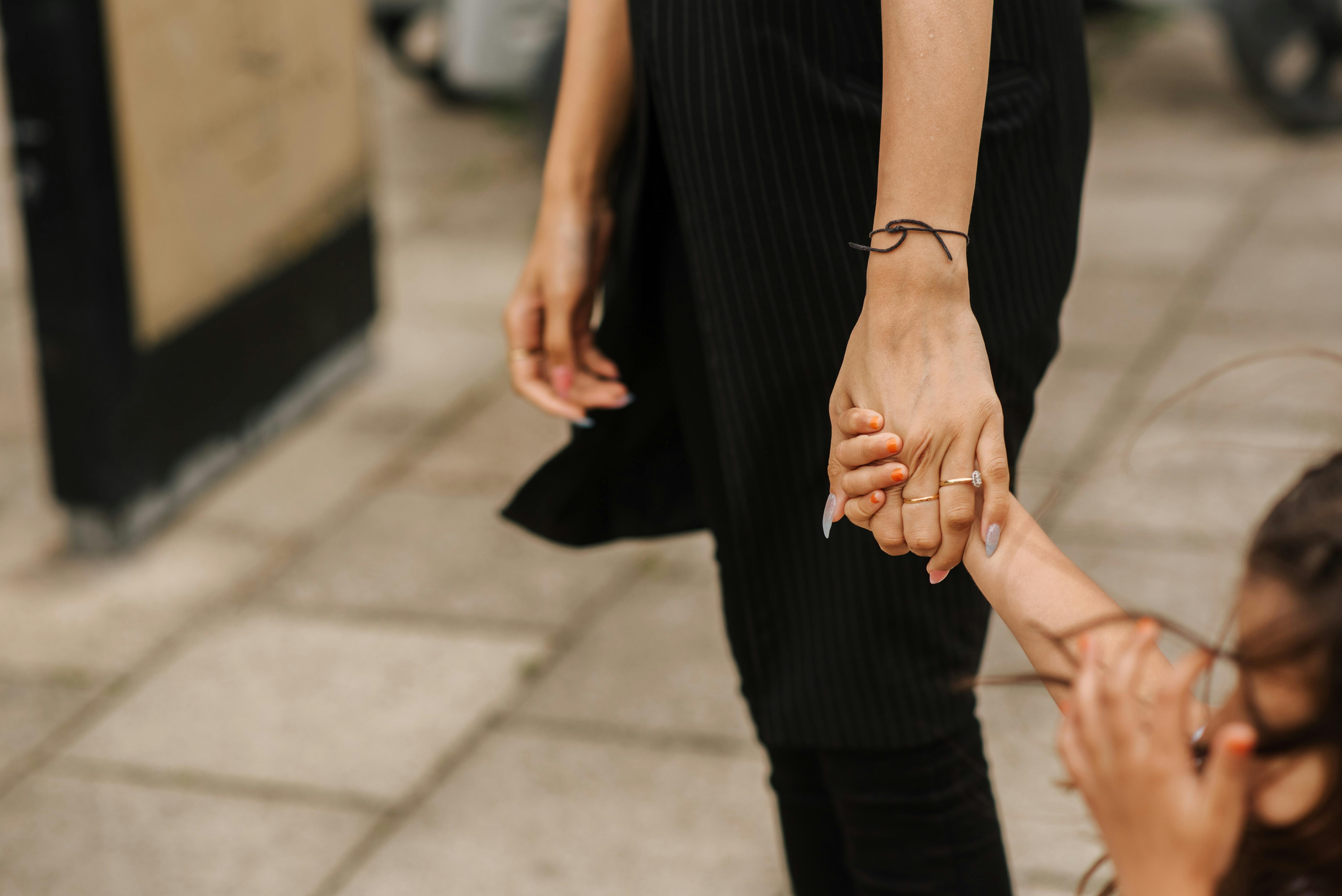 A woman holding her child's hand | Source: Pexels