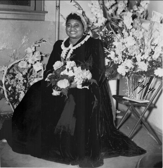 Hattie McDaniel smiles with flowers on her lap, circa1941 | Source: Wikimedia Commons Images, Public Domain