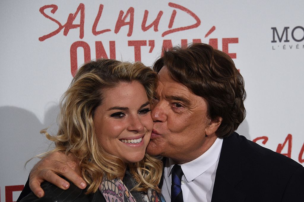 L'homme d'affaires français Bernard Tapie et sa fille Sophie Tapie posent avant la projection du nouveau film du réalisateur français Claude Lelouch "Salaud, on t'aime" ("Bâtard, nous t'aimons") le 31 mars 2014 à Paris . | Photo : Getty Images
