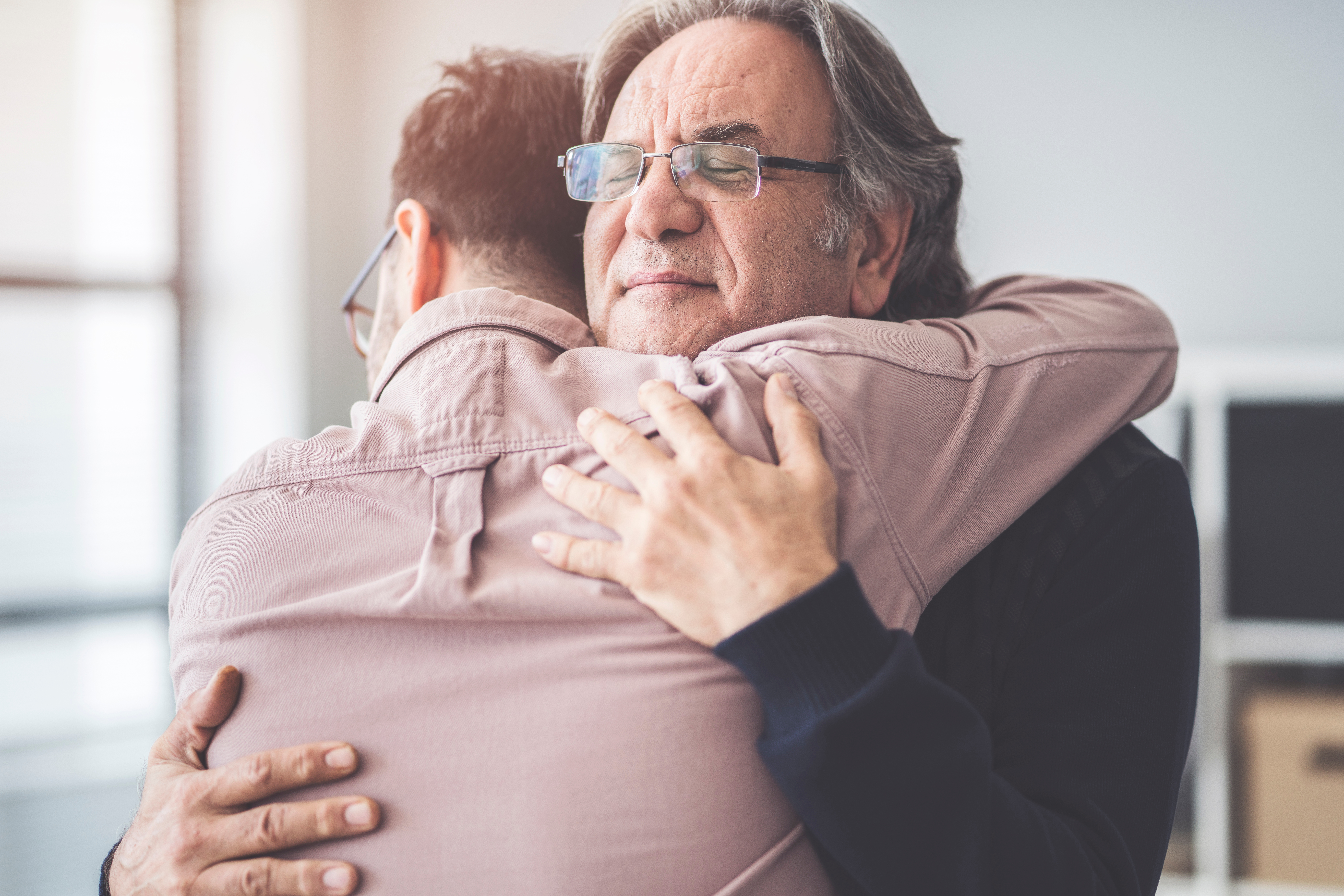A man hugging an older man | Source: Shutterstock